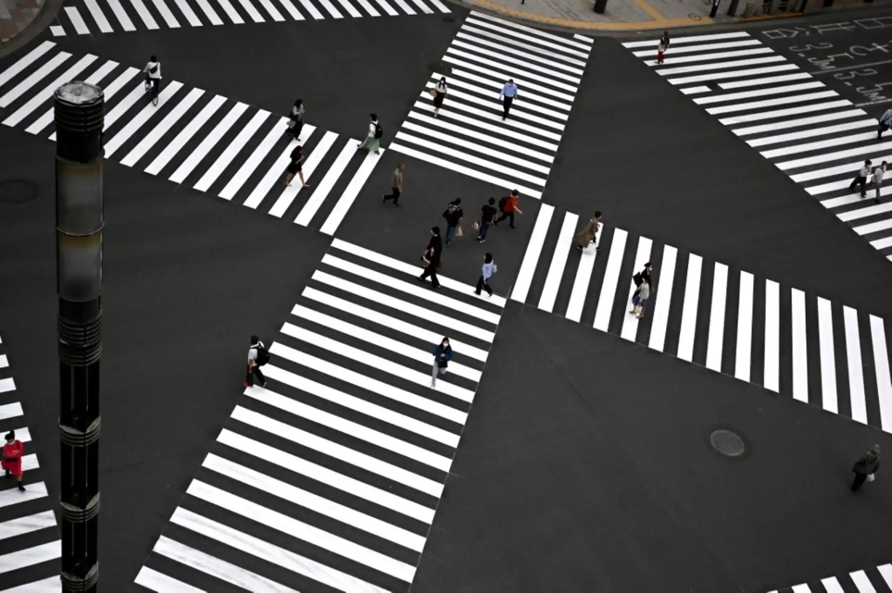 Las personas que usan máscaras faciales en medio de las preocupaciones por el coronavirus COVID-19 cruzan una calle en Tokio. Foto: AFP