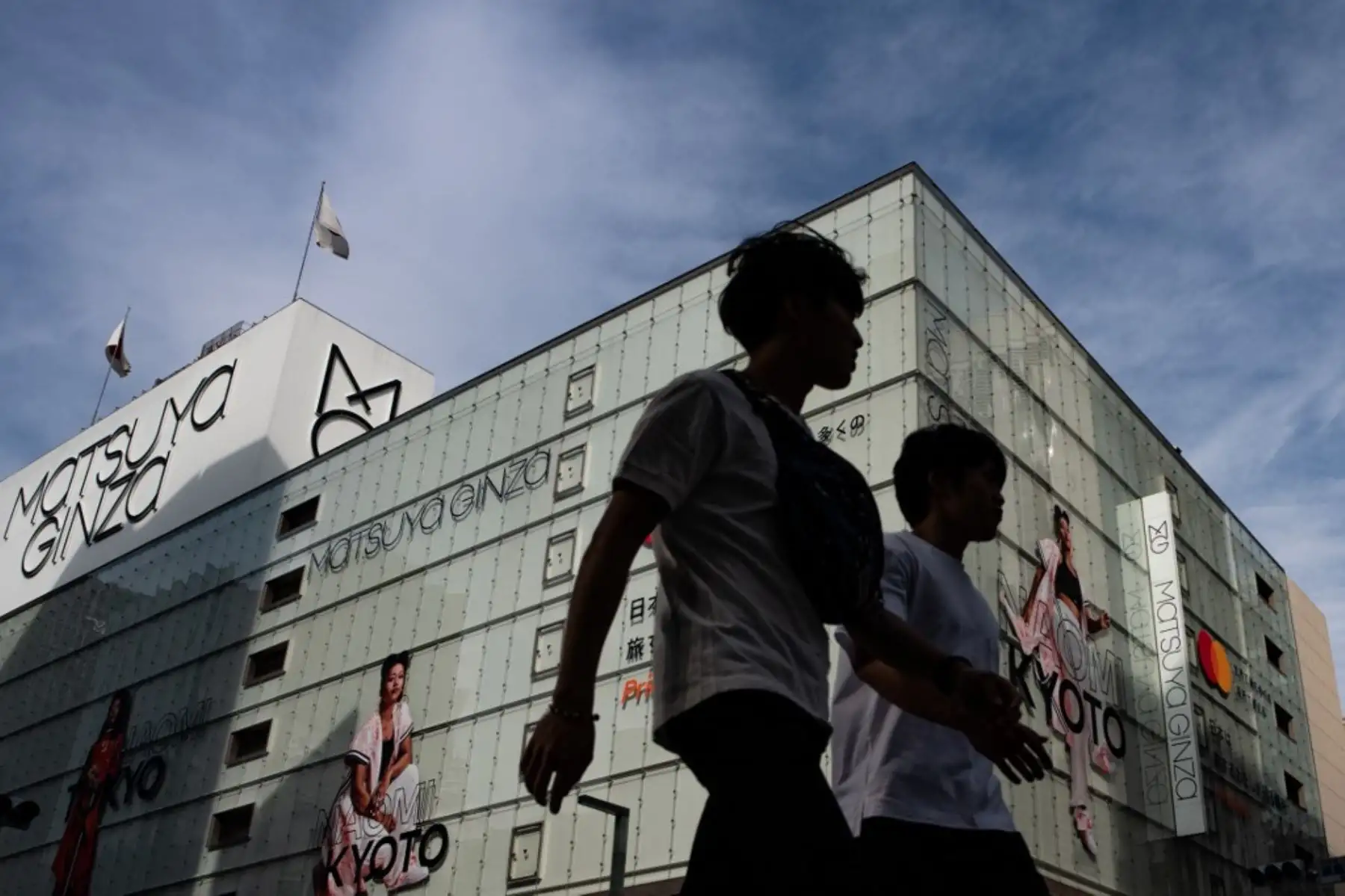 La gente pasa frente al edificio de grandes almacenes Matsuya en el distrito de Ginza, ya que su sección de alimentos en el sótano se reabre después de ser cerrada debido a las restricciones del coronavirus COVID-19 en Tokio. Foto: AFP