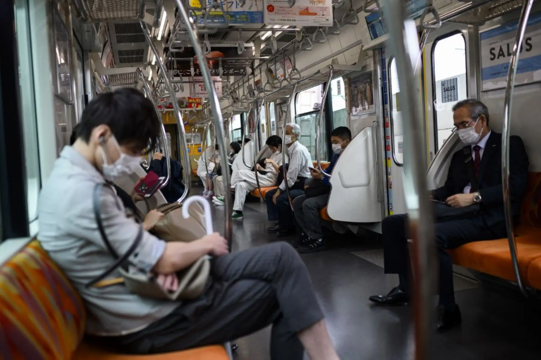 Personas con máscaras faciales en medio de la preocupación por la propagación del coronavirus COVID-19 en un tren en Tokio. Foto: AFP