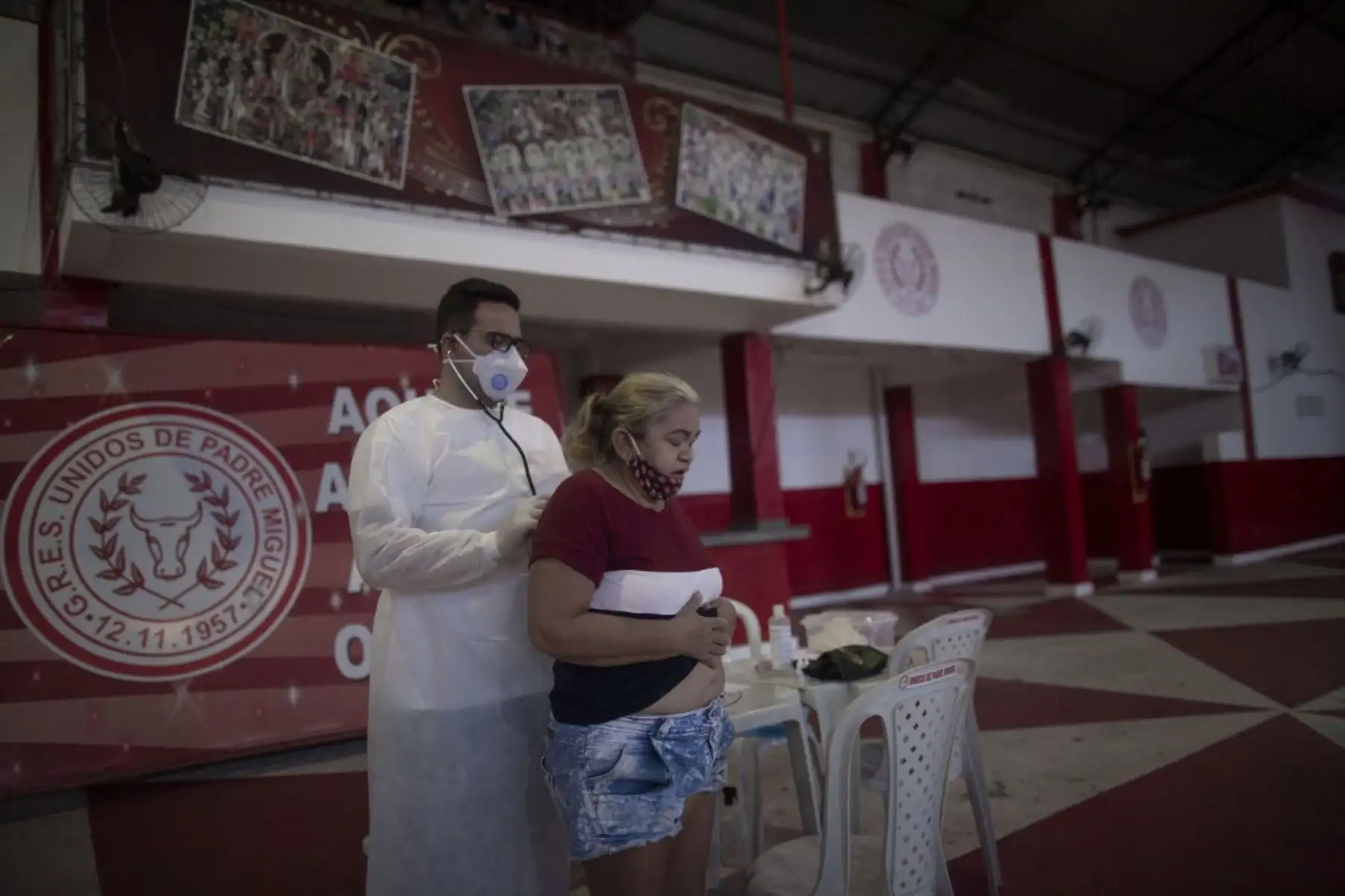 El médico Fabiano Simplicio atiende a una mujer que muestra síntomas del nuevo coronavirus, COVID-19, durante un día de controles de salud gratuitos en la sede de la escuela de samba Unidos de Padre Miguel en Río de Janeiro. Foto: AFP