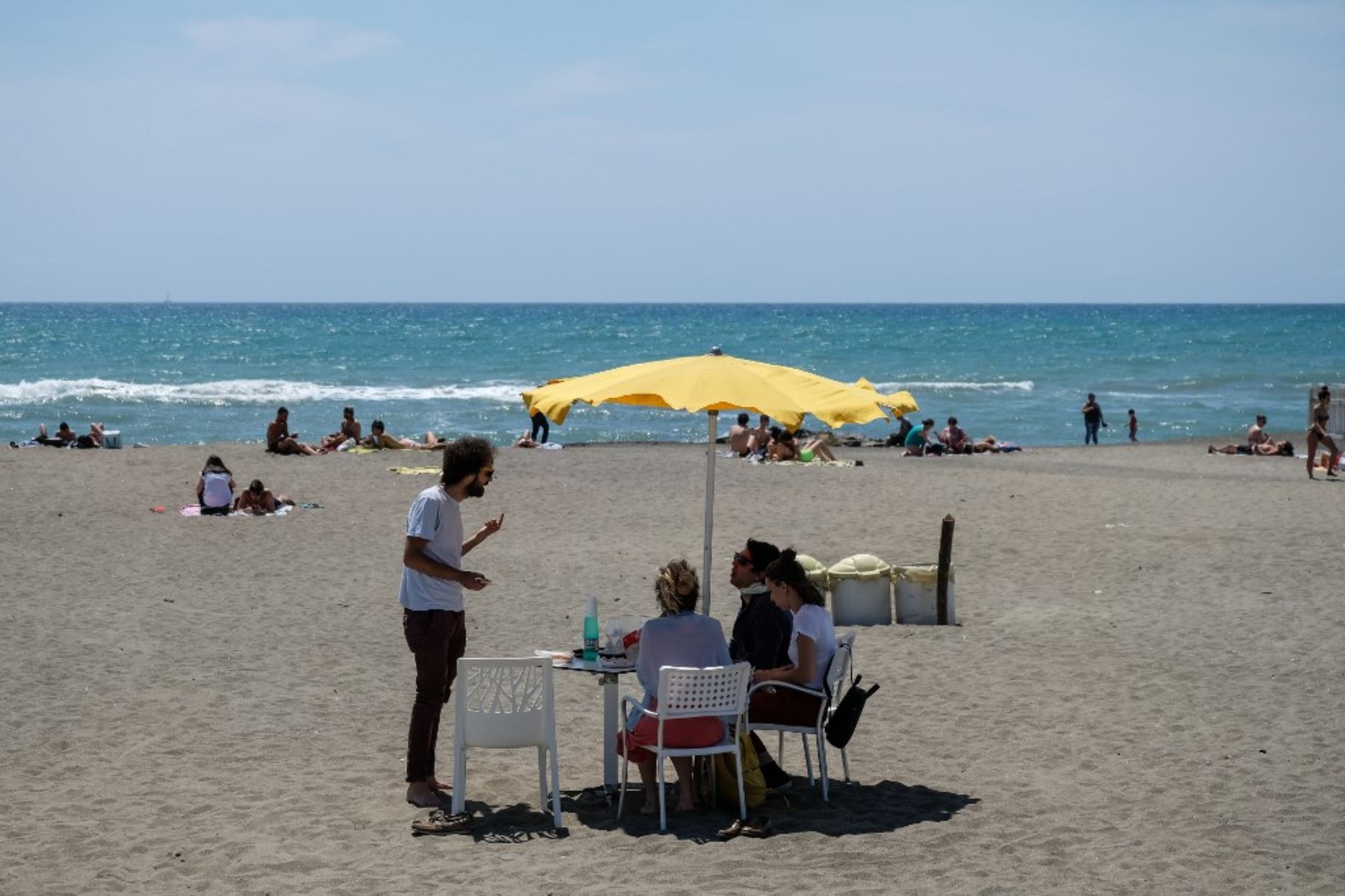 La gente disfruta del clima soleado en la playa en Ostia, al oeste de Roma, mientras el país alivia las medidas de cierre adoptadas para frenar la propagación de la pandemia de COVID-19. Foto: AFP
