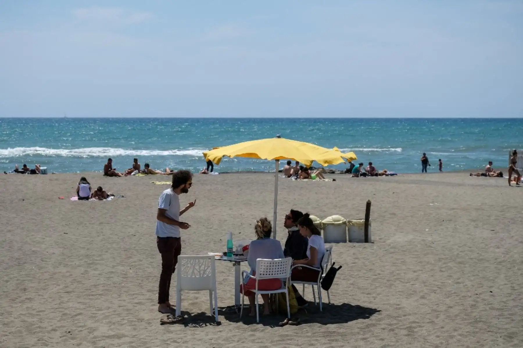 La gente disfruta del clima soleado en la playa en Ostia, al oeste de Roma, mientras el país alivia las medidas de cierre adoptadas para frenar la propagación de la pandemia de COVID-19. Foto: AFP