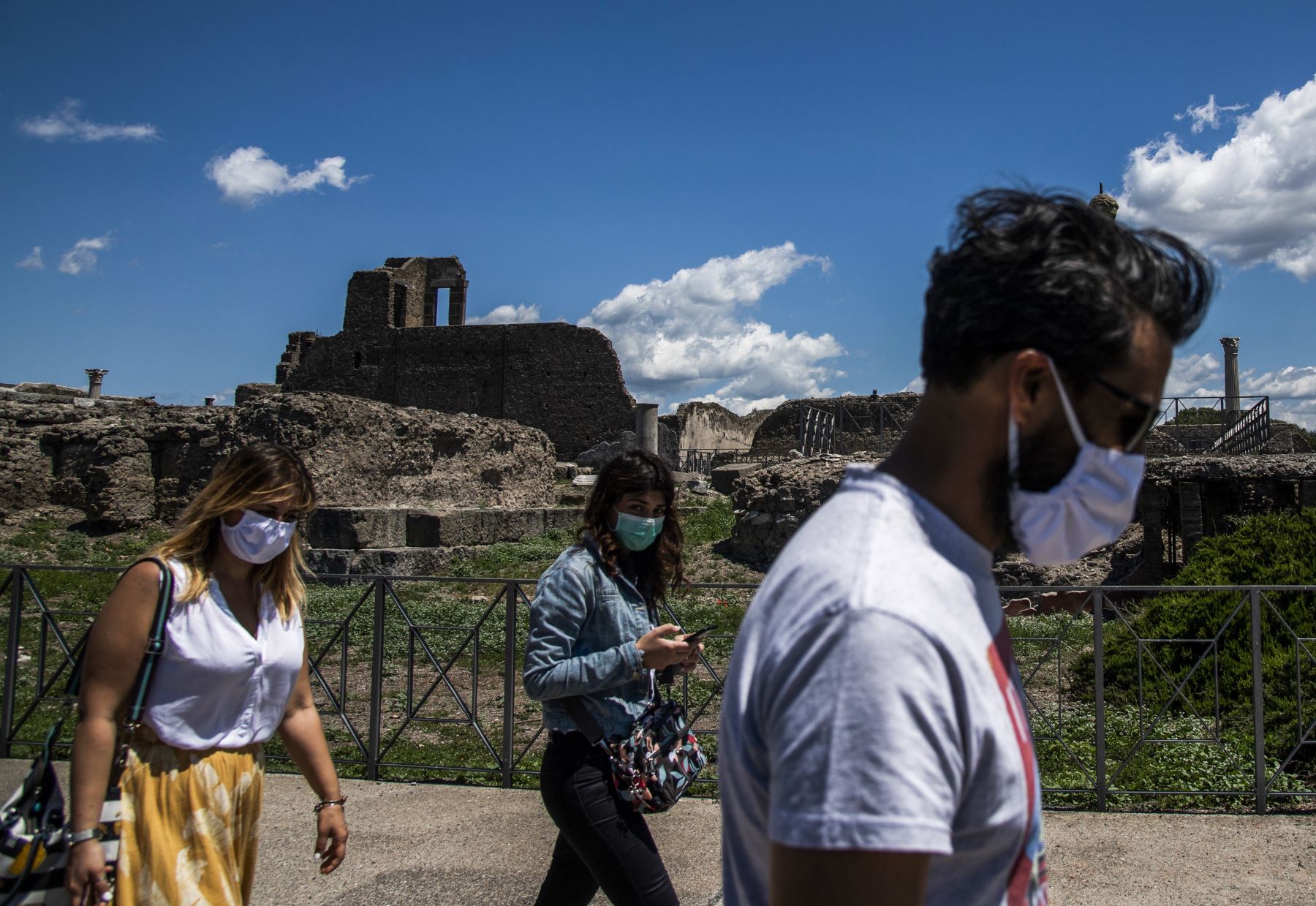 Las personas que usan una máscara facial visitan el sitio arqueológico de Pompeya el 26 de mayo de 2020, mientras el país alivia su bloqueo para frenar la propagación de la infección por COVID-19. Foto: AFP