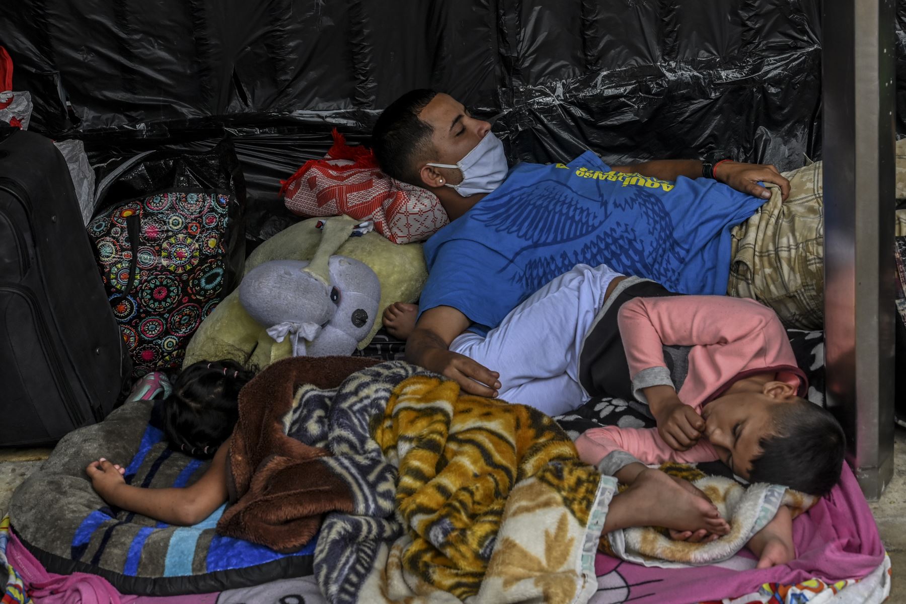 Los migrantes venezolanos que desean regresar a su país debido a la nueva pandemia de coronavirus COVID-19, acampan frente a la terminal de autobuses en Medellín. Foto: AFP