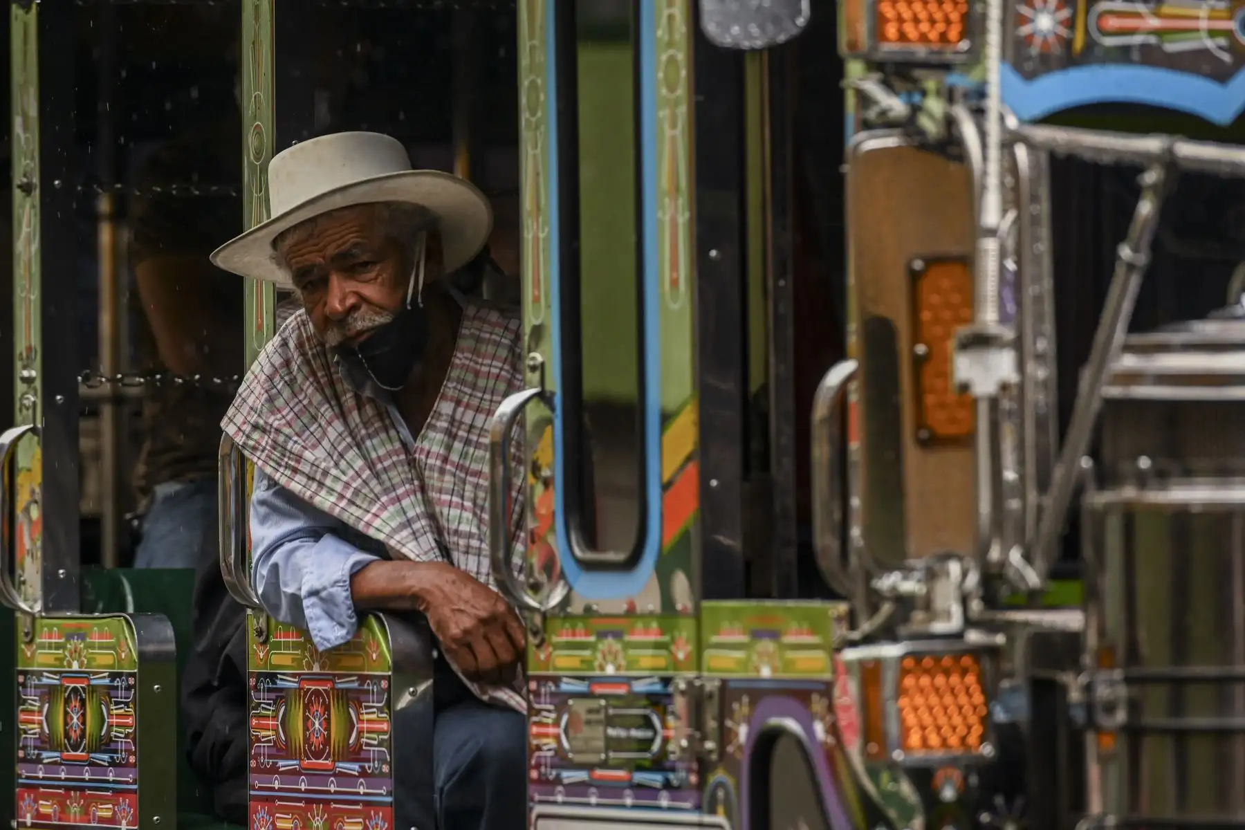Un hombre con una máscara facial como medida preventiva para detener la propagación del nuevo coronavirus Covid-19, es fotografiado en un autobús en el municipio de Guarne, departamento de Antioquia. Foto: AFP