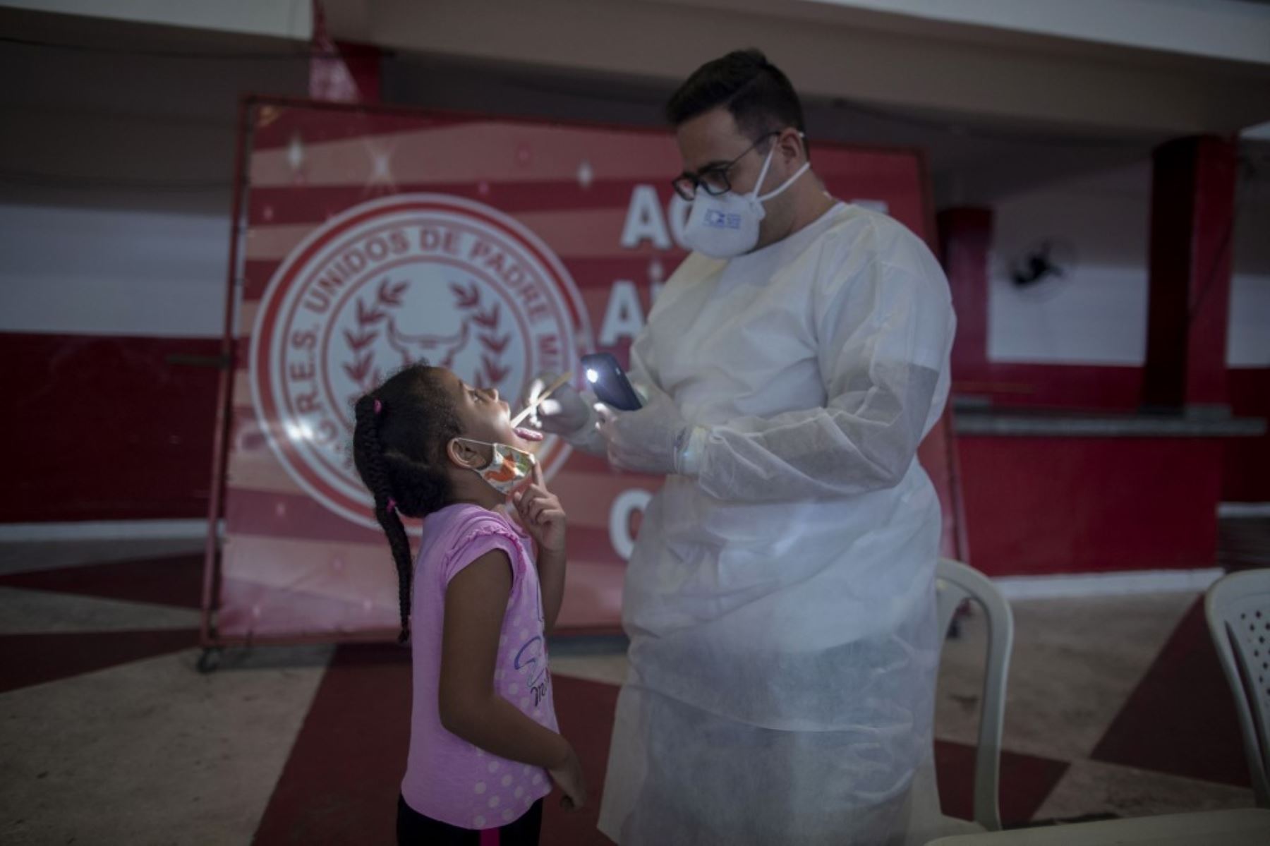 El médico Fabiano Simplicio atiende a una niña que muestra síntomas del nuevo coronavirus, COVID-19. Foto: AFP