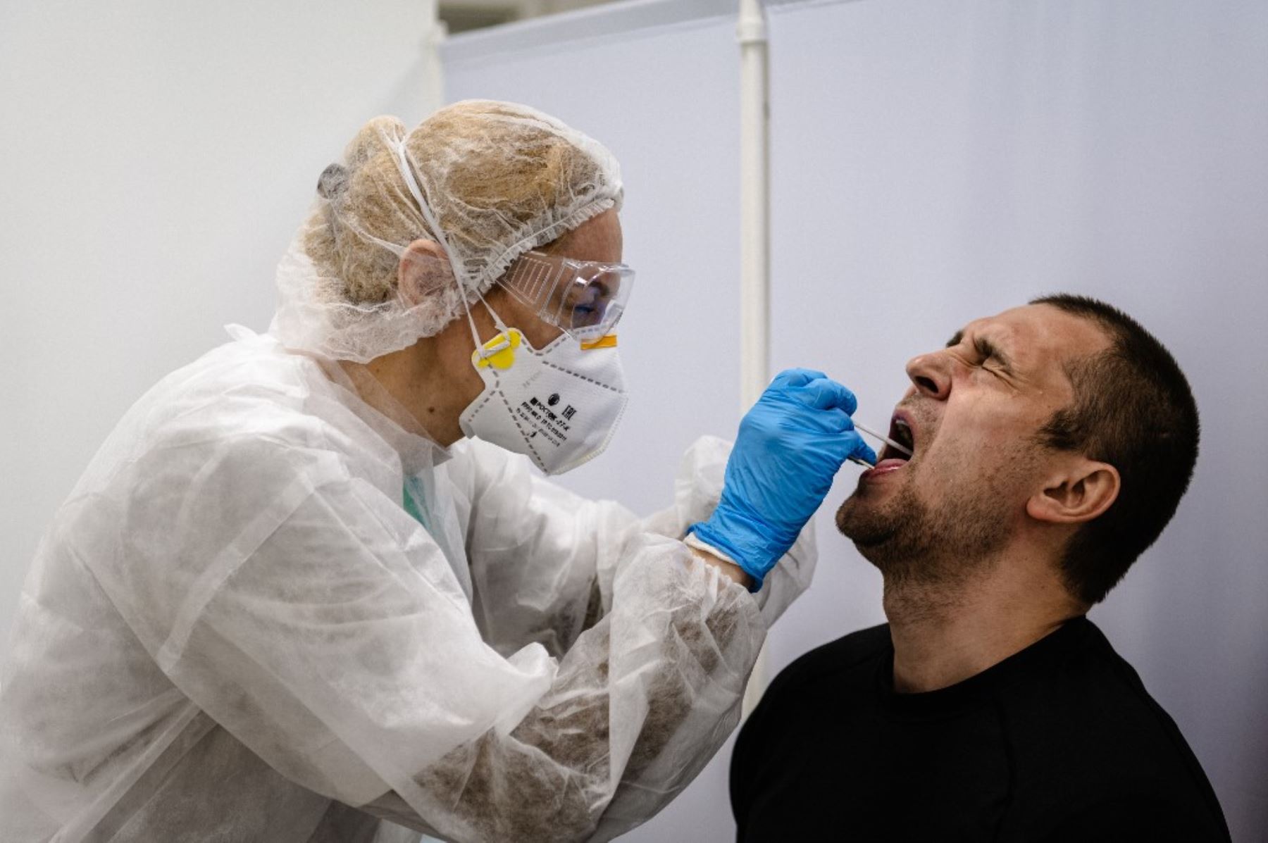 Una enfermera toma una muestra con un hisopo a un hombre para analizar el coronavirus COVID-19. Foto: AFP