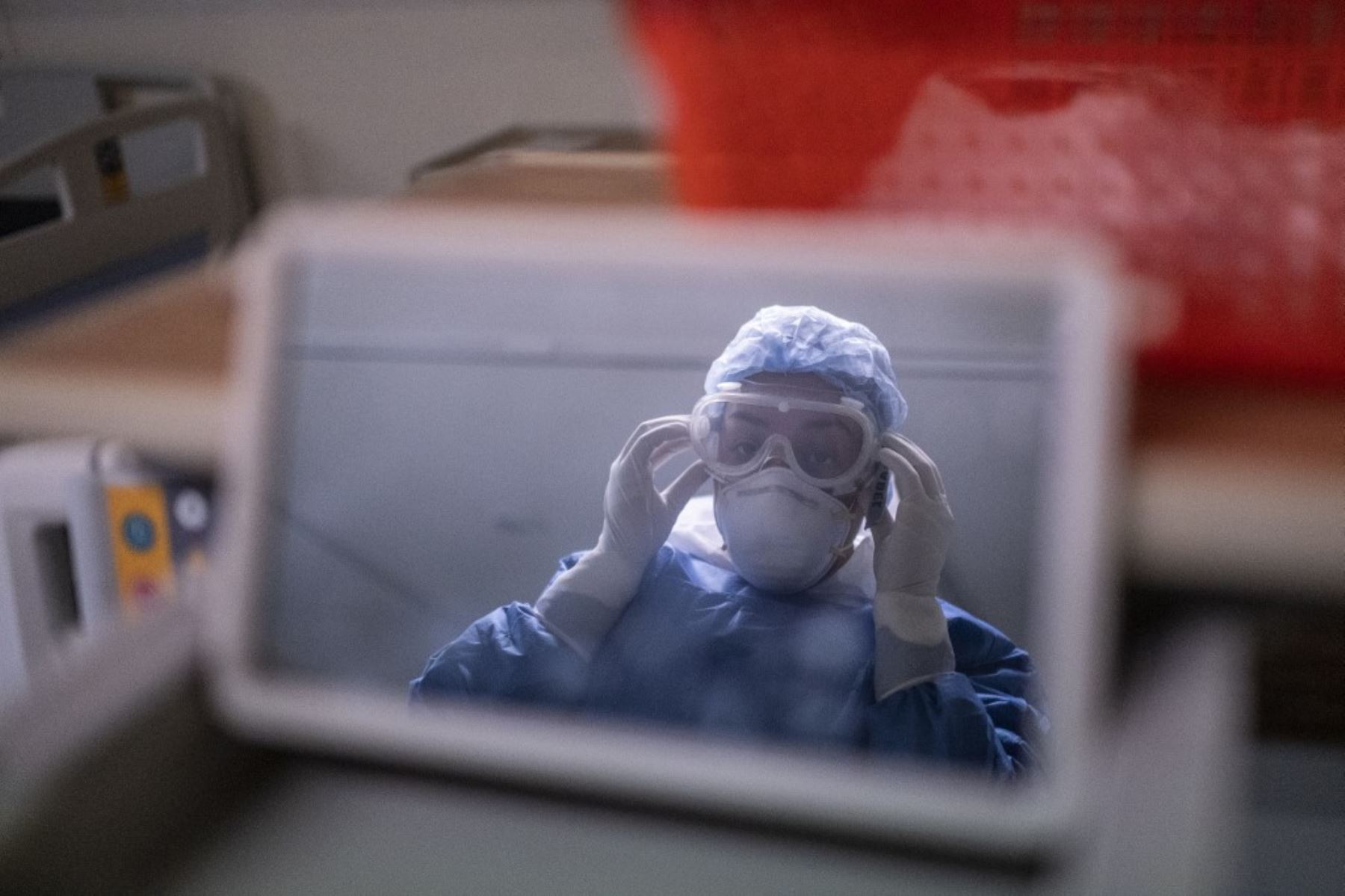 Un trabajador de la salud se refleja en un espejo mientras se prepara para ingresar a la zona COVID-19 de un hospital en Atizapan, México. Foto. AFP