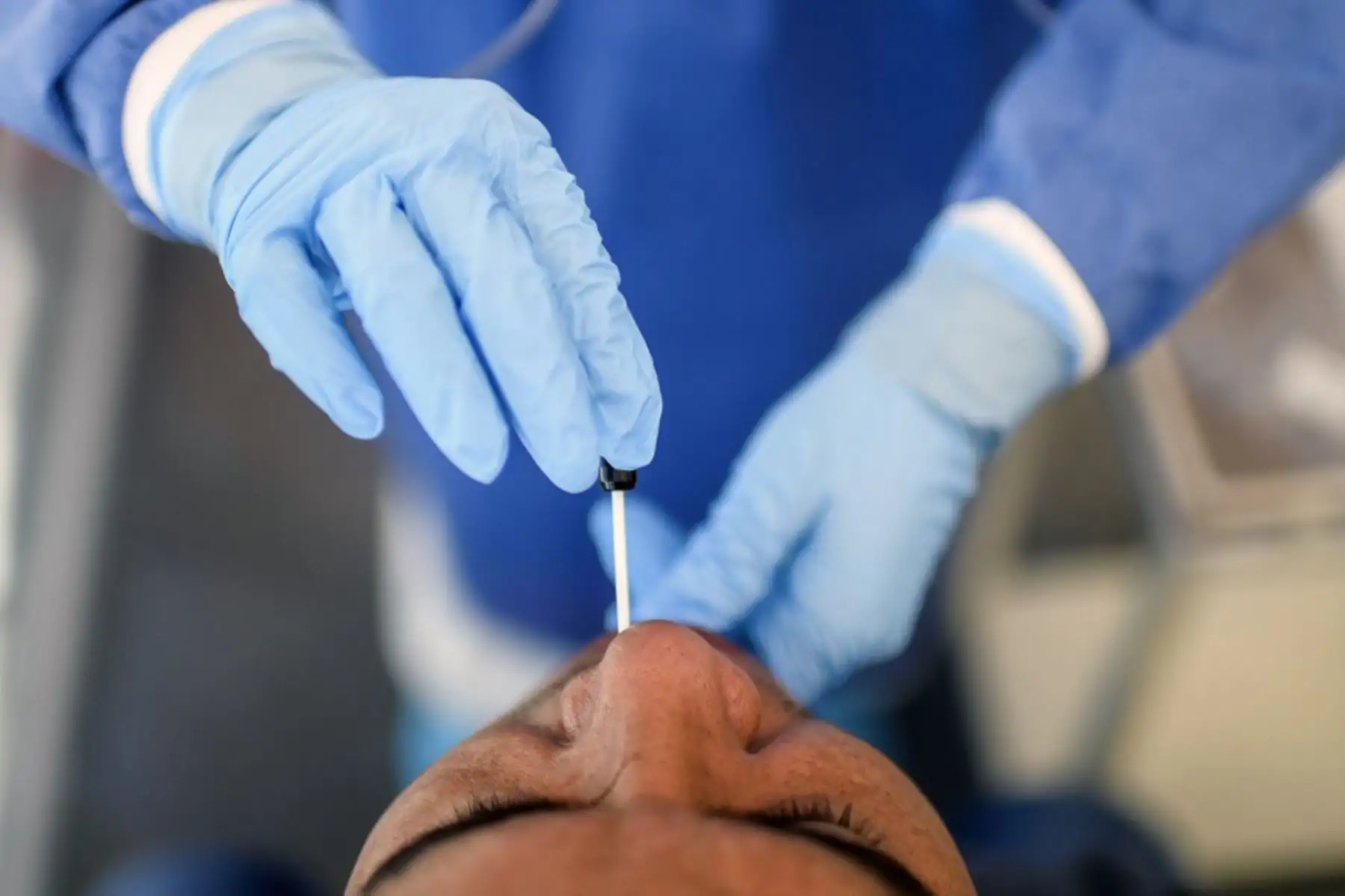 Un trabajador de salud toma muestras de un hombre para examinarlo para detectar el coronavirus COVID-19. Foto: AFP