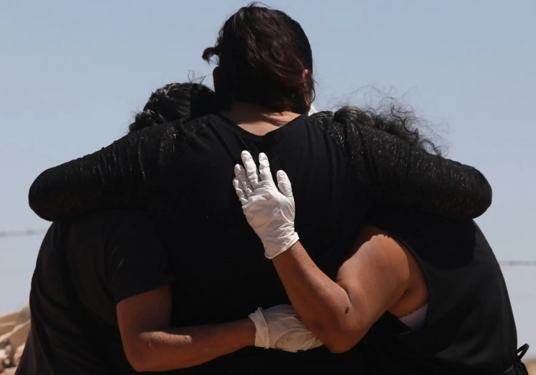 Los familiares de una presunta víctima de COVID-19 lloran mientras los trabajadores del cementerio entierran el ataúd en un área del panteón municipal de San Rafael reservada para las víctimas del nuevo coronavirus, en Ciudad Juárez. Foto: AFP