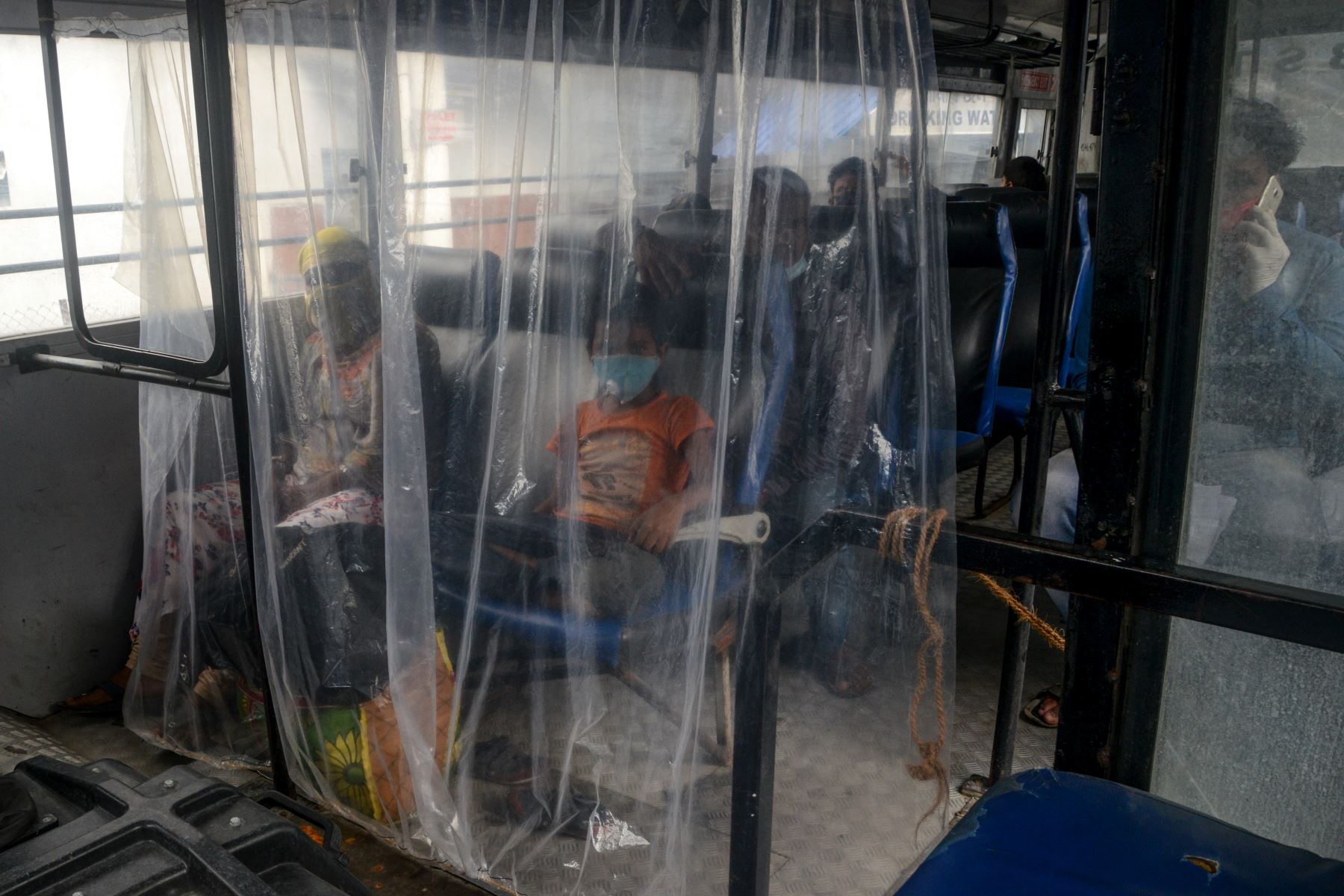 Los pasajeros viajan en un autobús estatal manteniendo el distanciamiento social después de que los servicios de autobuses se reanuden después de que el gobierno alivió un bloqueo nacional impuesto como medida preventiva contra el coronavirus COVID-19, en Siliguri, India. Foto: AFP