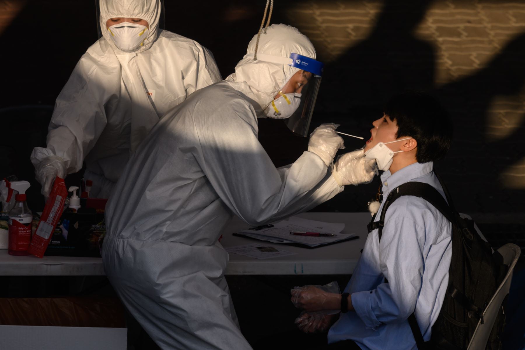 Un trabajador de la salud administra un hisopo en un nuevo centro temporal de pruebas de coronavirus COVID-19 en Bucheon, al sur de Seúl. Foto: AFP