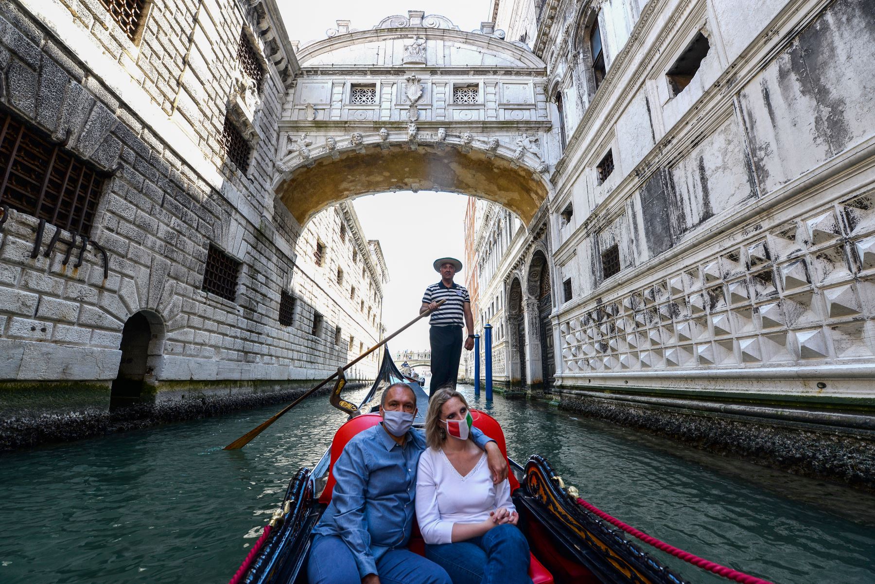 Las personas disfrutan de un paseo en góndola bajo el Puente de los Suspiros (Ponte dei Sospiri) en Venecia. Foto: AFP