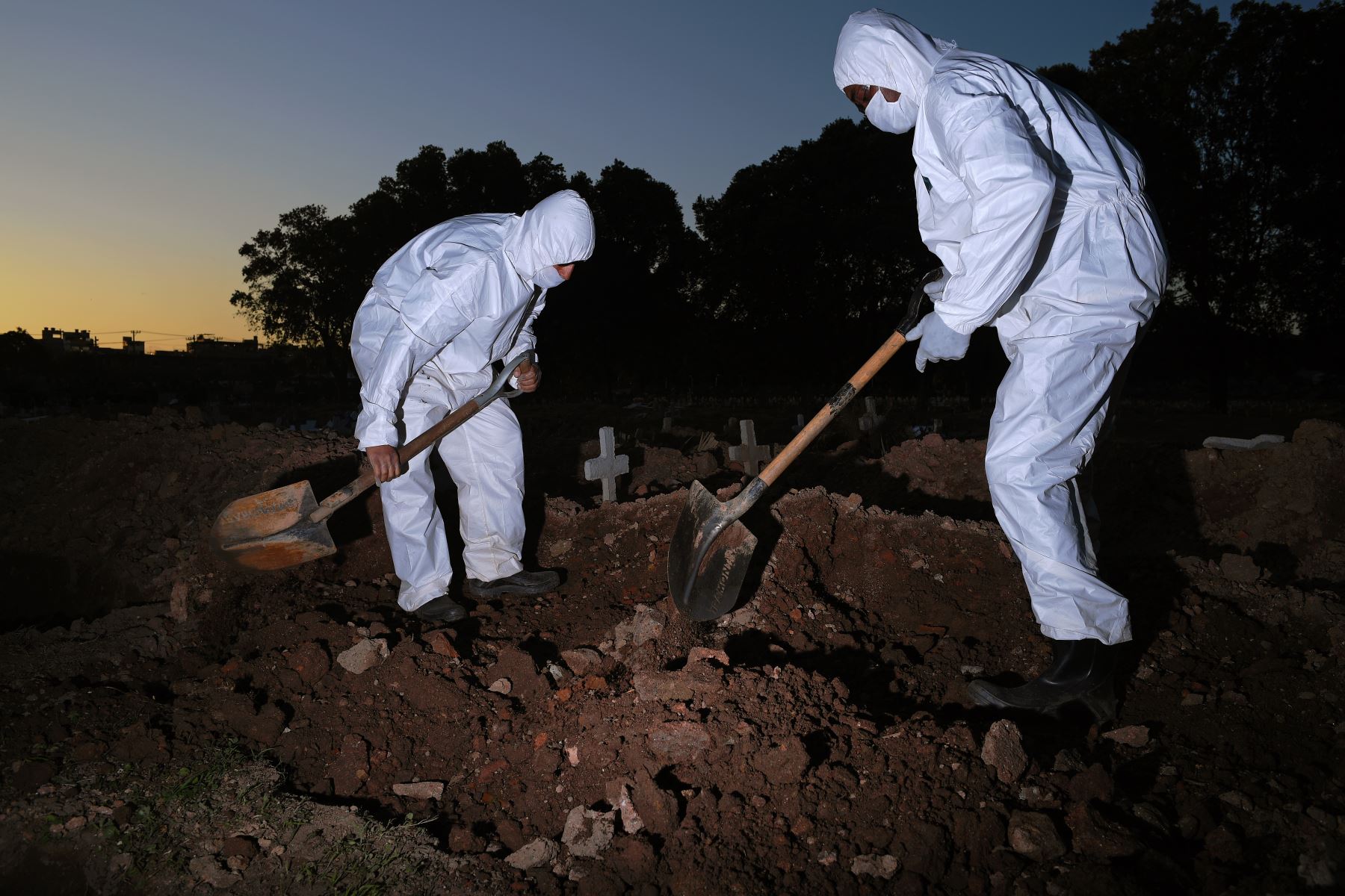 Los trabajadores del cementerio con ropa protectora entierran a una víctima de COVID-19 en el cementerio de Sao Francisco Xavier en Río de Janeiro, Brasil. Foto: AFP