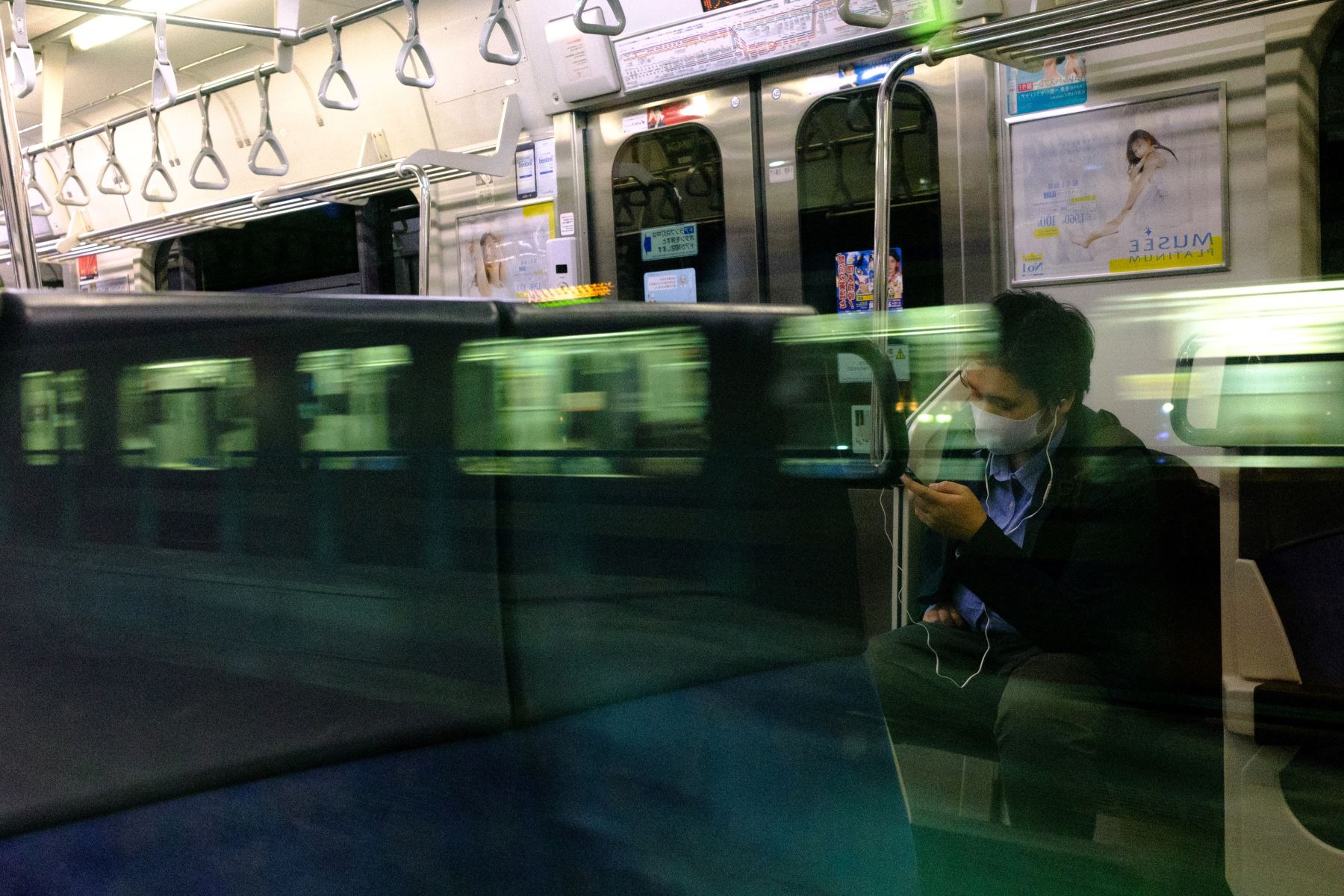 Un hombre con una máscara facial viaja en un tren a Tokio el 30 de mayo de 2020. Foto: AFP