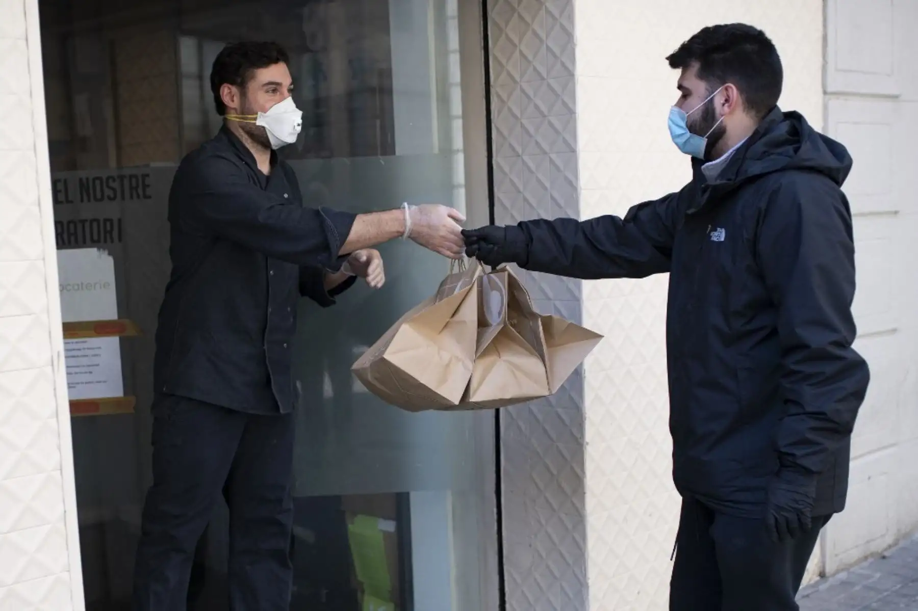 Un repartidor que trabaja para Delivery4Heroes llega a un restaurante para recoger bolsas con alimentos para el personal sanitario que se enfrenta al nuevo coronavirus en Barcelona. Foto: AFP