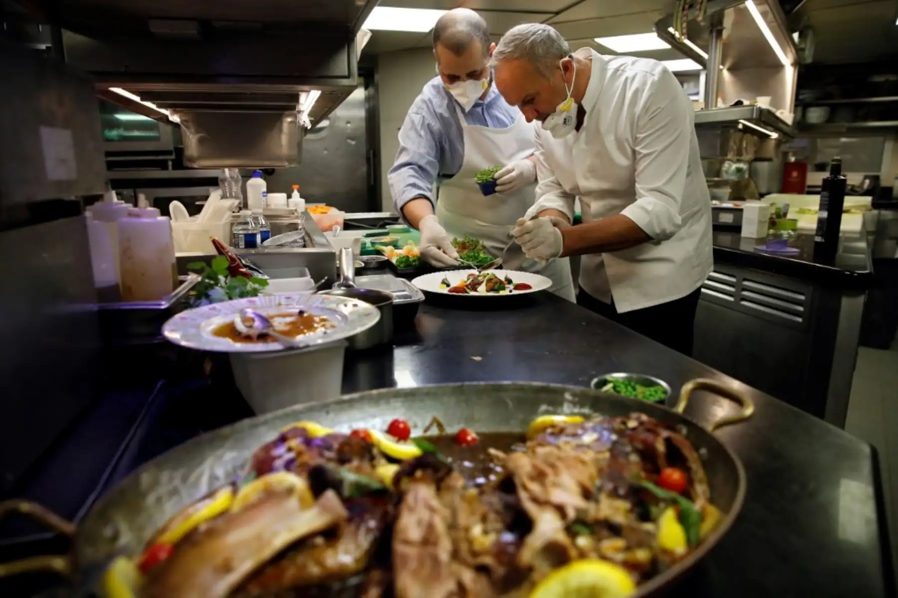 El chef francés de 3 estrellas Christian Le Squer y el chef de una estrella Alan Taudon cocinan para empleados de un hospital parisino en la cocina del restaurante "Le Cinq" en el hotel Four Season George V Palace en París. Foto: AFP