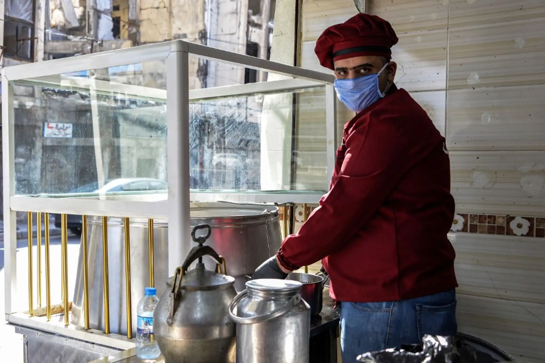 Un cocinero que usa una máscara quirúrgica en un restaurante que sirve "pacha", un plato tradicional local tradicional en Mosul, Irak. Foto: AFP