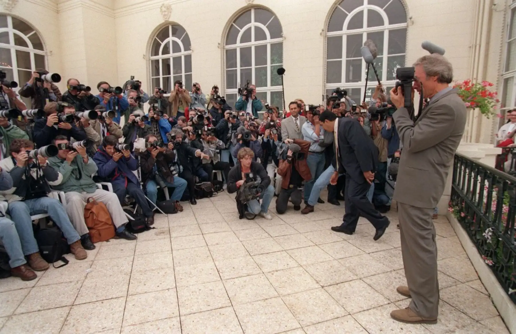 El actor y director de cine estadounidense Clint Eastwood toma una foto a un grupo de los fotógrafos,  en la terraza del casino durante el 21 ° festival de cine estadounidense de Deauville, el 2 de septiembre de 1995. Foto: AFP