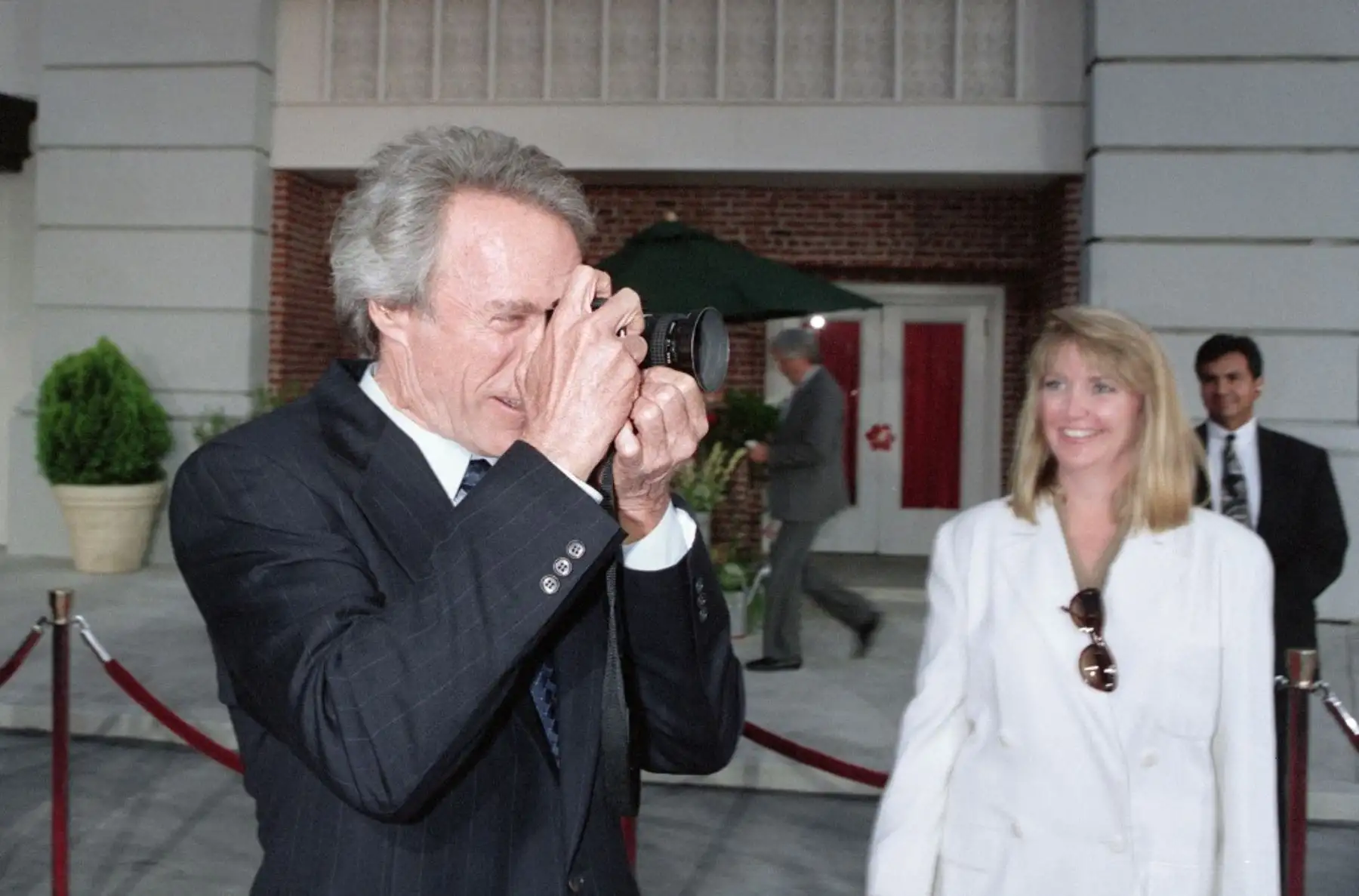 El actor estadounidense Clint Eastwood toma fotografías con la cámara de un fotógrafo en el estreno mundial "The Bridge of Madison County", el 30 de mayo de la película en Burbank, California. Foto: AFP