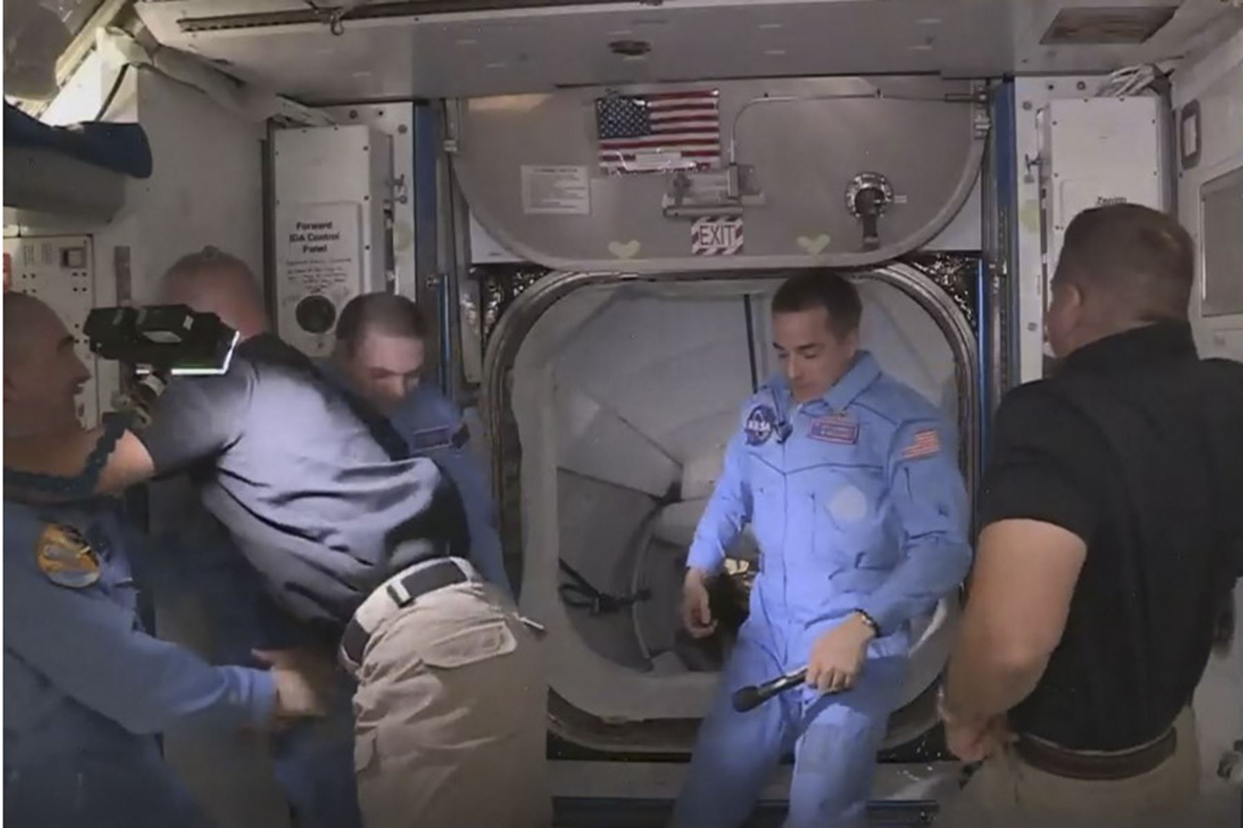 Esta imagen de captura de fotogramas de la NASA muestra a los astronautas de la NASA Crew Dragon de SpaceX Douglas Hurley (L) y Robert Behnken (R) llegando después de que la escotilla se abrió a la Estación Espacial Internacional el 31 de mayo de 2020 con otros astronautas. Foto: AFP