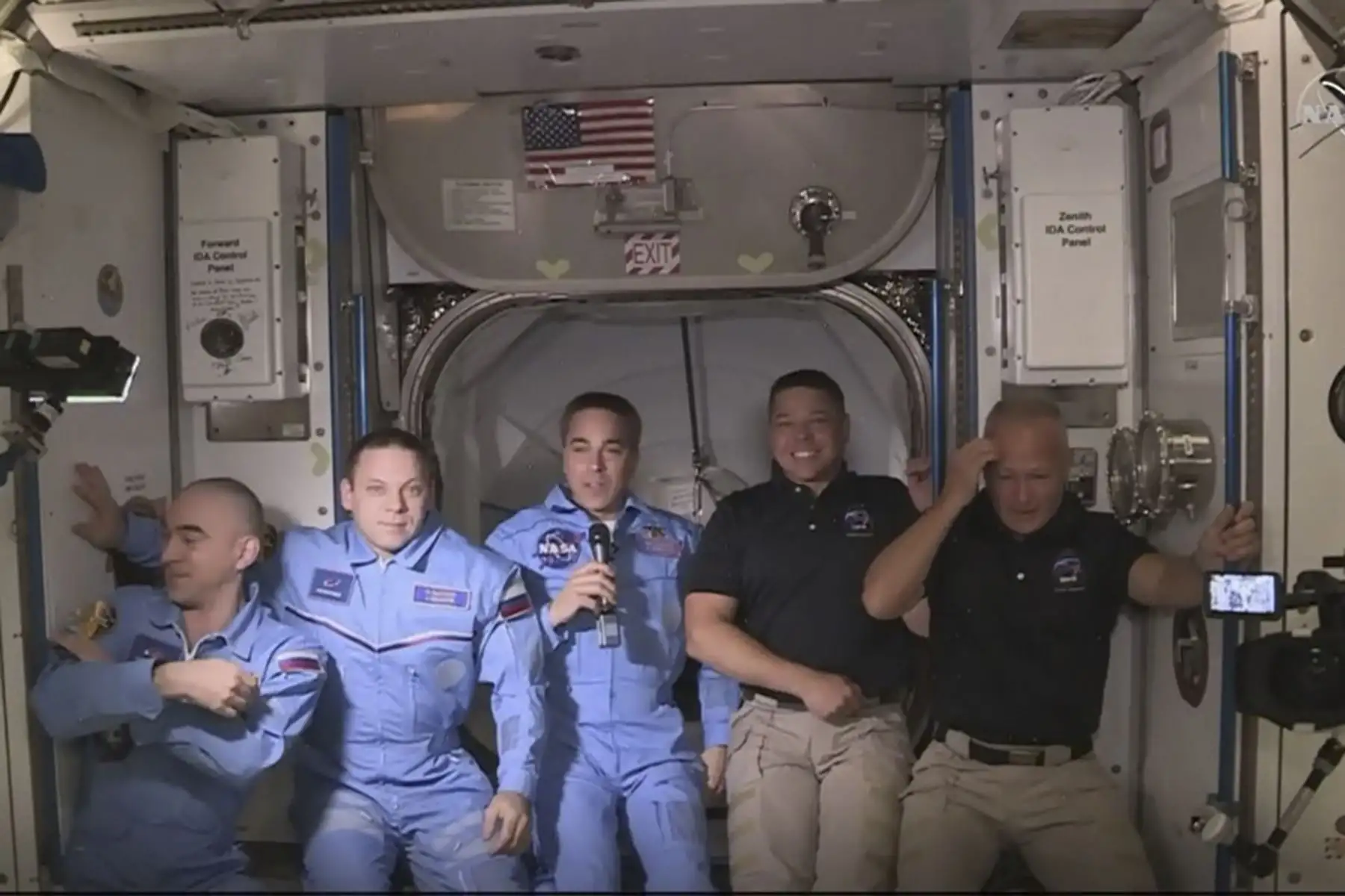 Esta imagen de captura de fotogramas de la NASA muestra a los astronautas de la NASA Crew Dragon de SpaceX Douglas Hurley (L) y Robert Behnken (R) llegando después de que la escotilla se abrió a la Estación Espacial Internacional el 31 de mayo de 2020 con otros astronautas. Foto: AFP