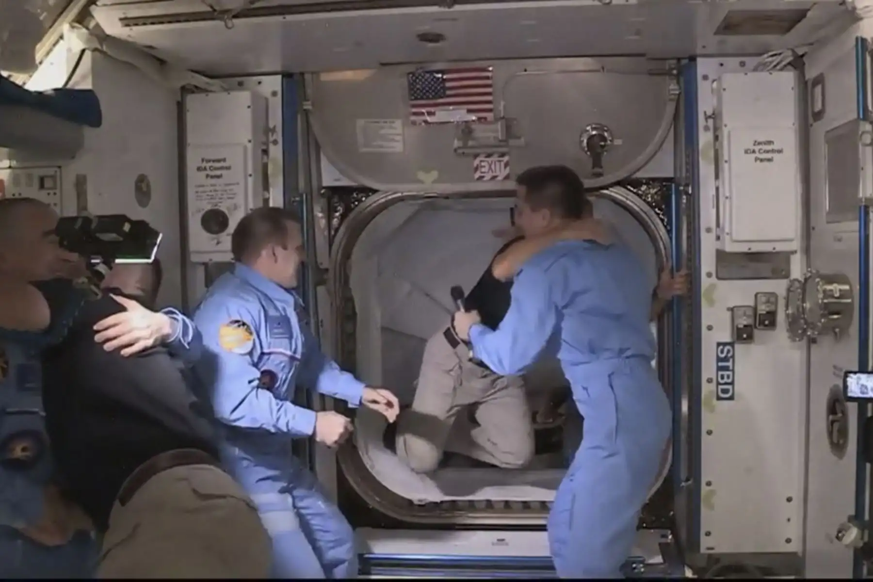 Esta imagen de captura de fotogramas de la NASA muestra a los astronautas de la NASA Crew Dragon de SpaceX Douglas Hurley (I) y Robert Behnken (D) llegando después de que la escotilla se abrió a la Estación Espacial Internacional el 31 de mayo de 2020 con otros astronautas. Foto: AFP