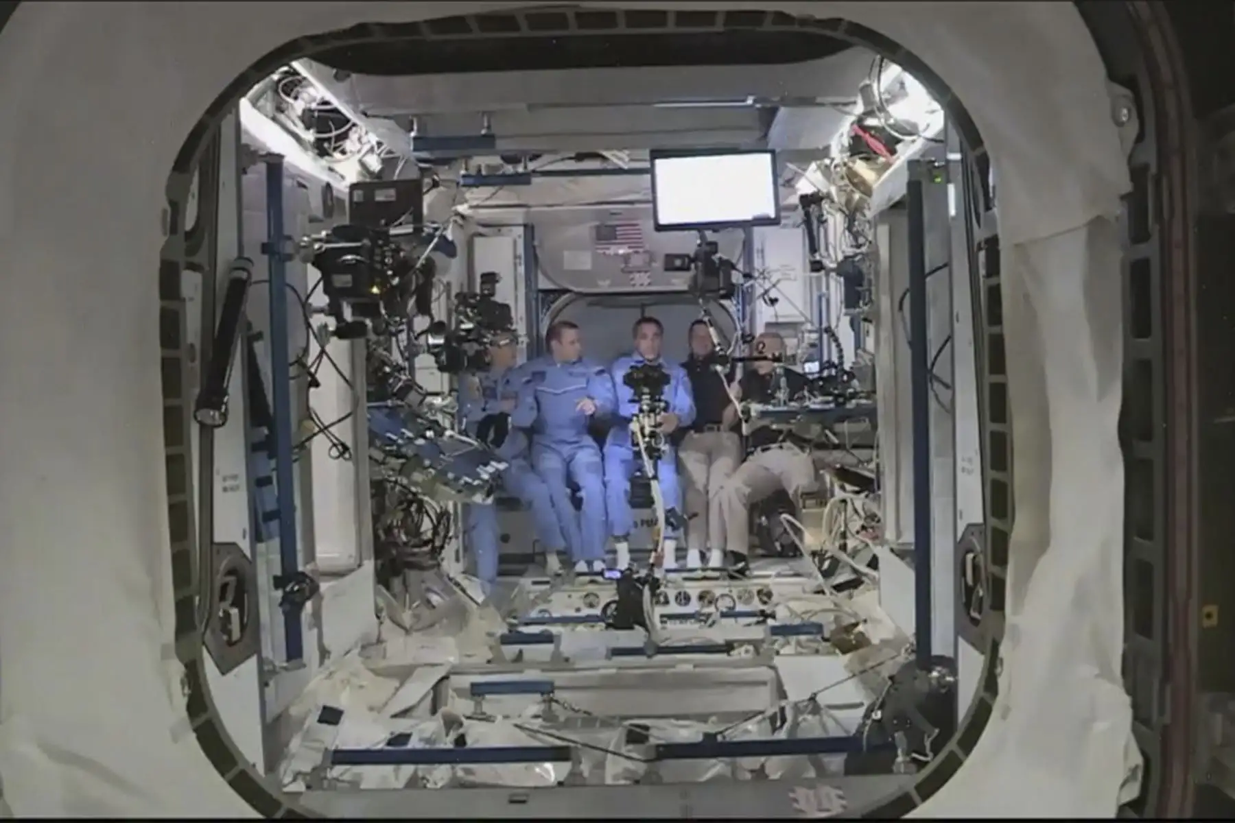 Esta imagen de captura de fotogramas de la NASA muestra a los astronautas de la NASA Crew Dragon de SpaceX Douglas Hurley (L) y Robert Behnken (R) llegando después de que la escotilla se abrió a la Estación Espacial Internacional el 31 de mayo de 2020 con otros astronautas. Foto: AFP