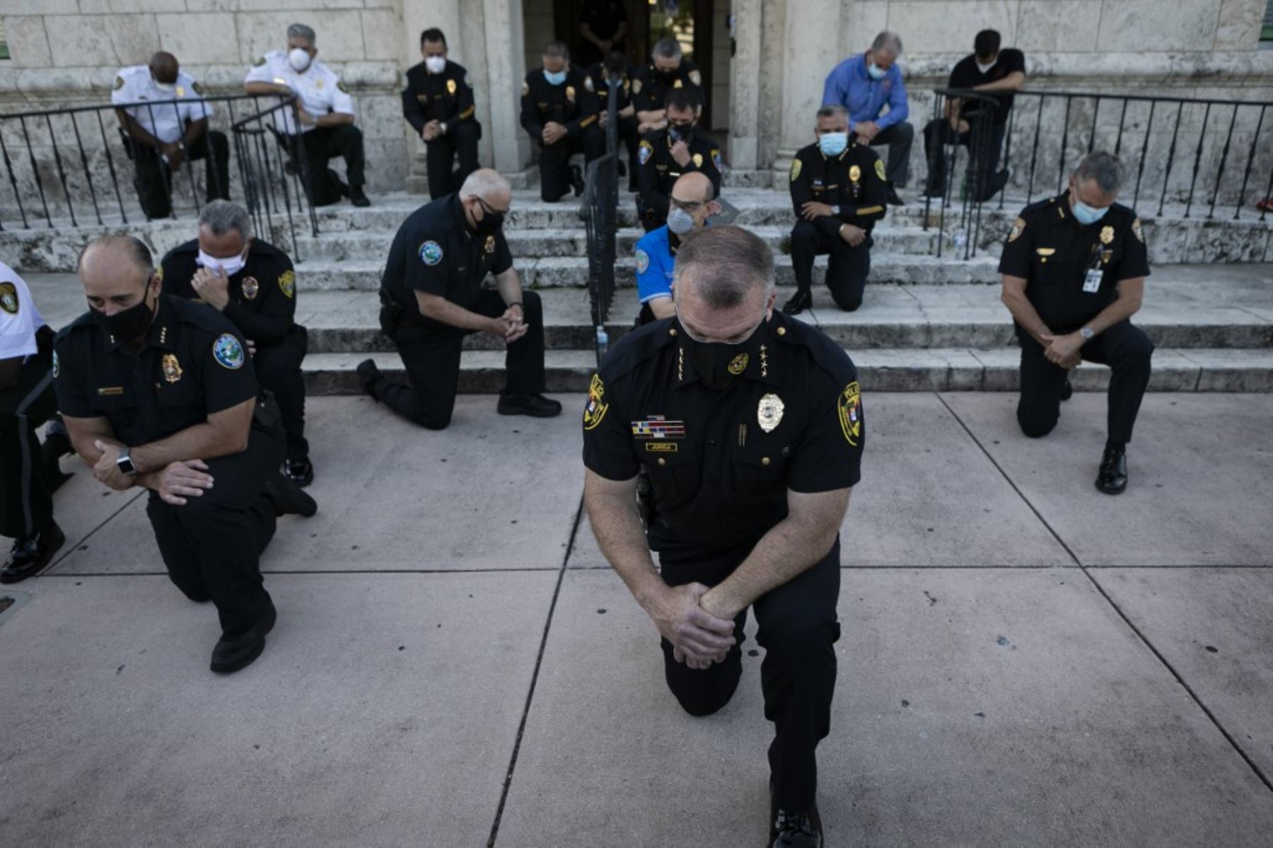 Los oficiales de policía se arrodillaron durante una manifestación en Coral Gables, Florida, el 30 de mayo de 2020 en respuesta a la reciente muerte de George Floyd. Foto: AFP