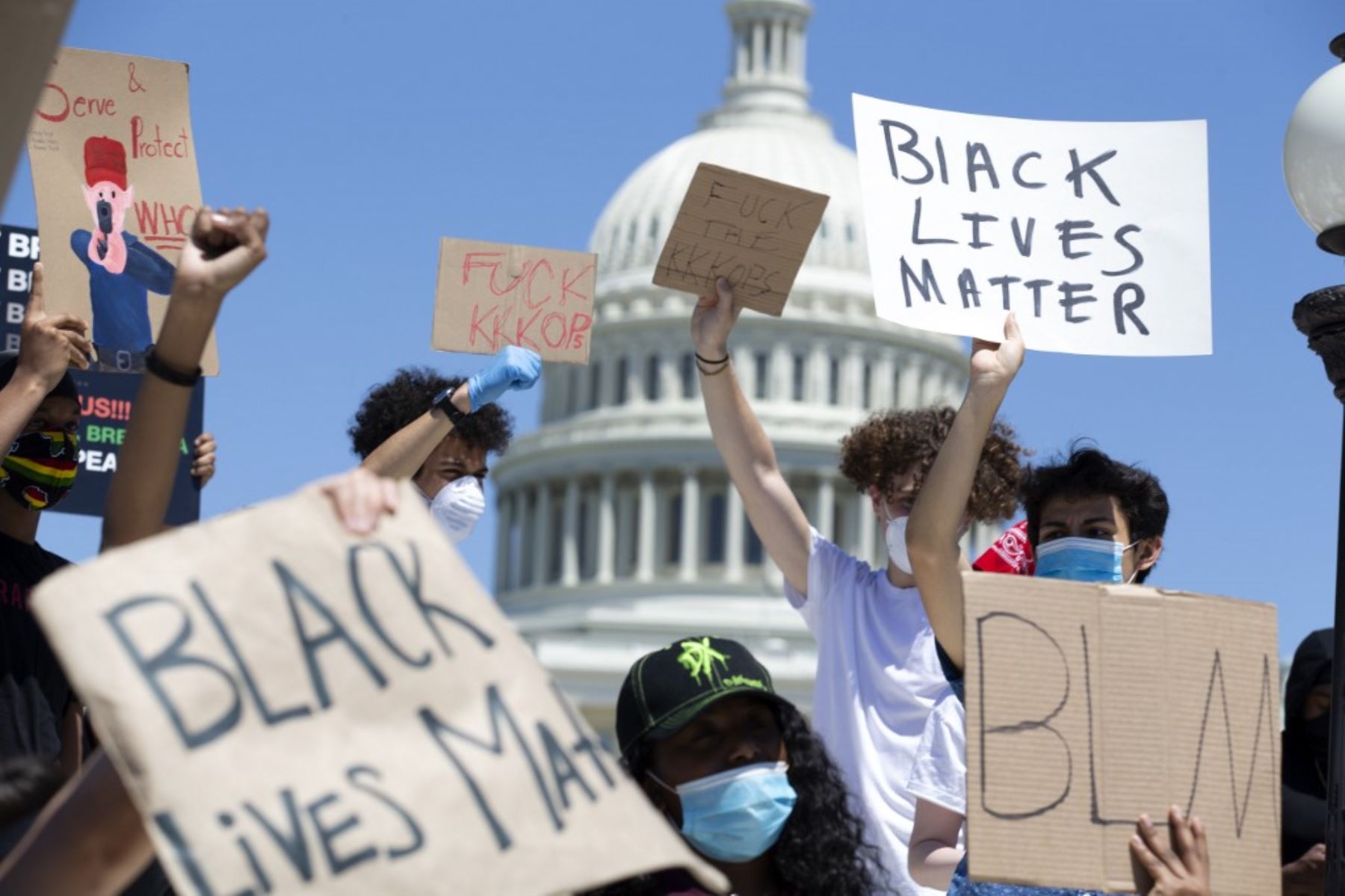 Los manifestantes sostienen sus carteles en Capitol Hill, el 30 de mayo de 2020 en Washington D.C., durante una protesta por la muerte de George Floyd. Foto: AFP