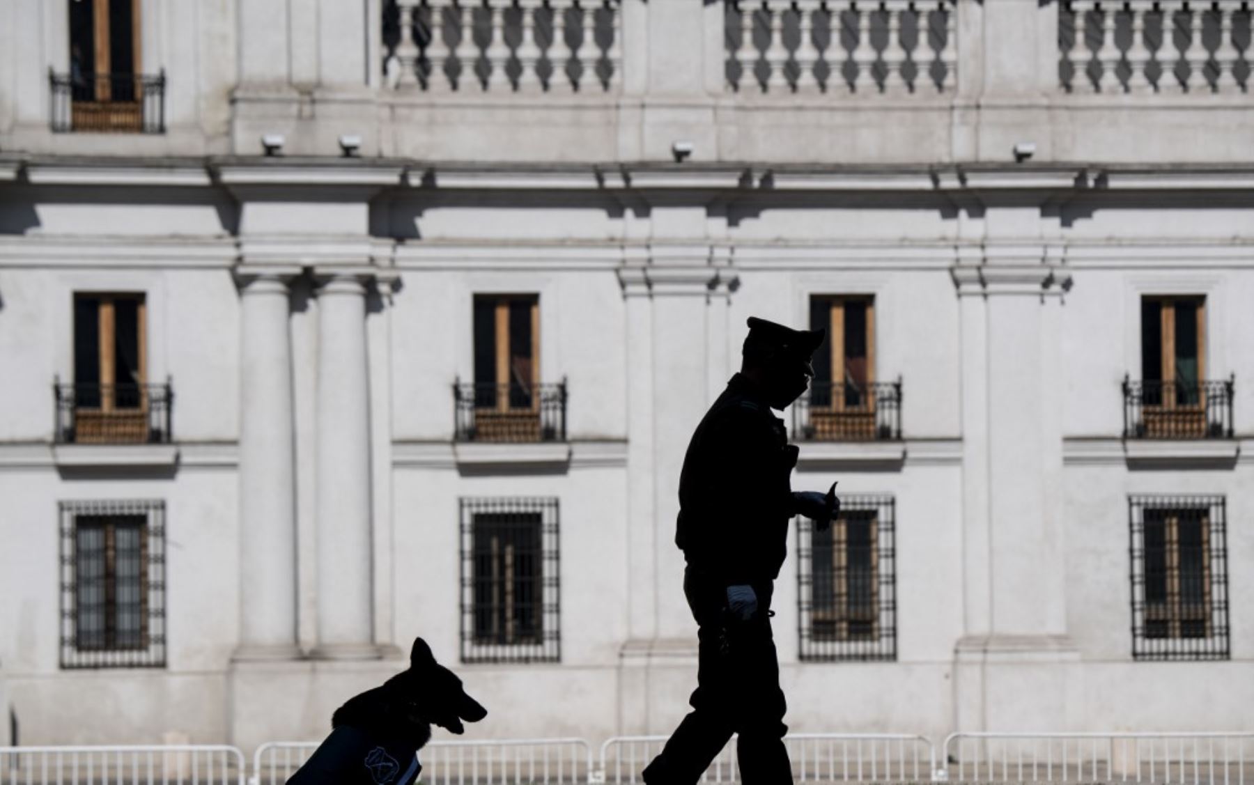 Un policía y su perro hacen guardia afuera del palacio presidencial de La Moneda en Santiago. Foto: AFP