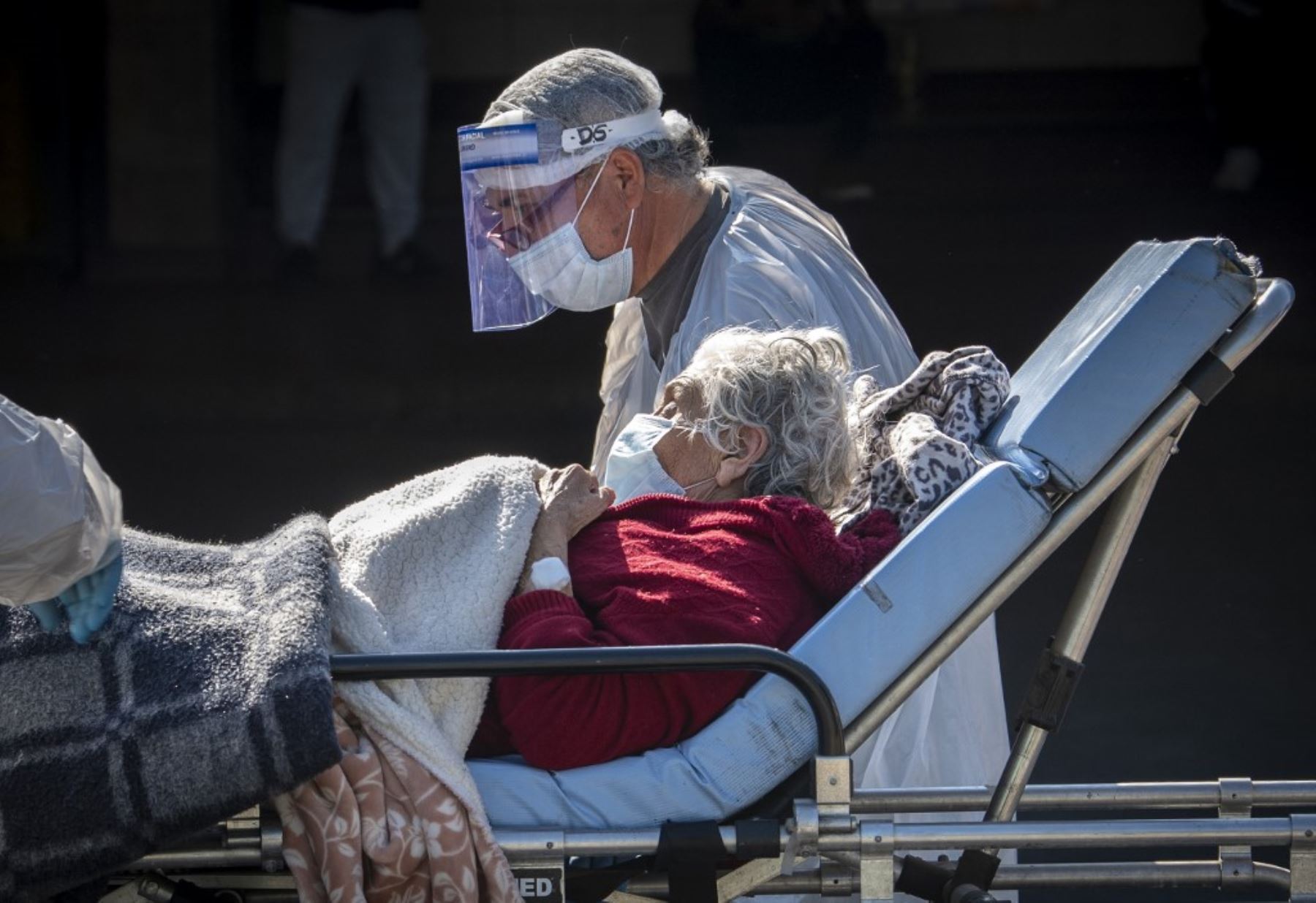 Una anciana que había sido afectada por el nuevo coronavirus COVID-19 está acompañada por un pariente después de ser dada de alta del hospital, en Santiago. Foto: AFP