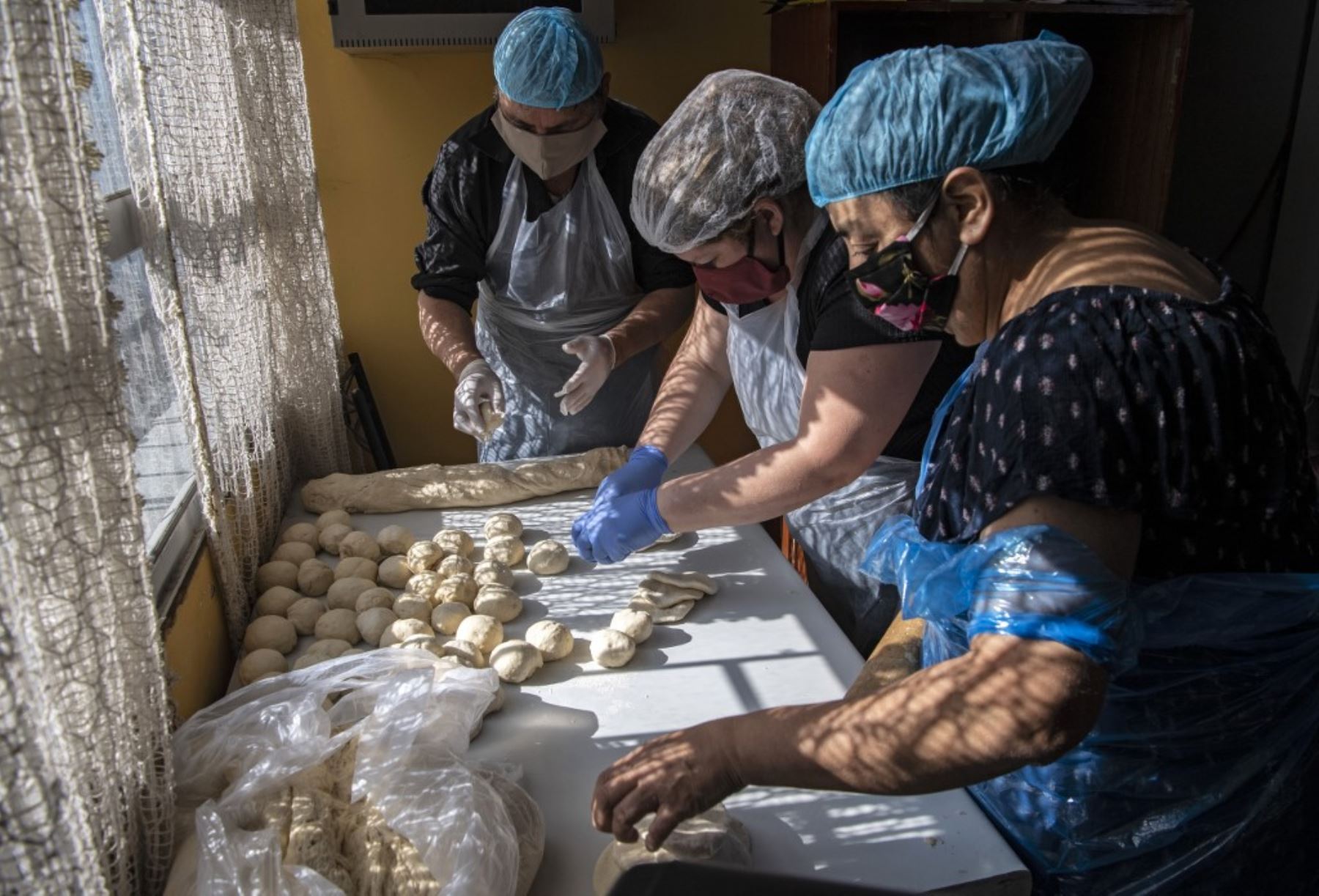 Los voluntarios preparan el almuerzo en un comedor popular en el barrio de La Pintana, Santiago. Foto: AFP