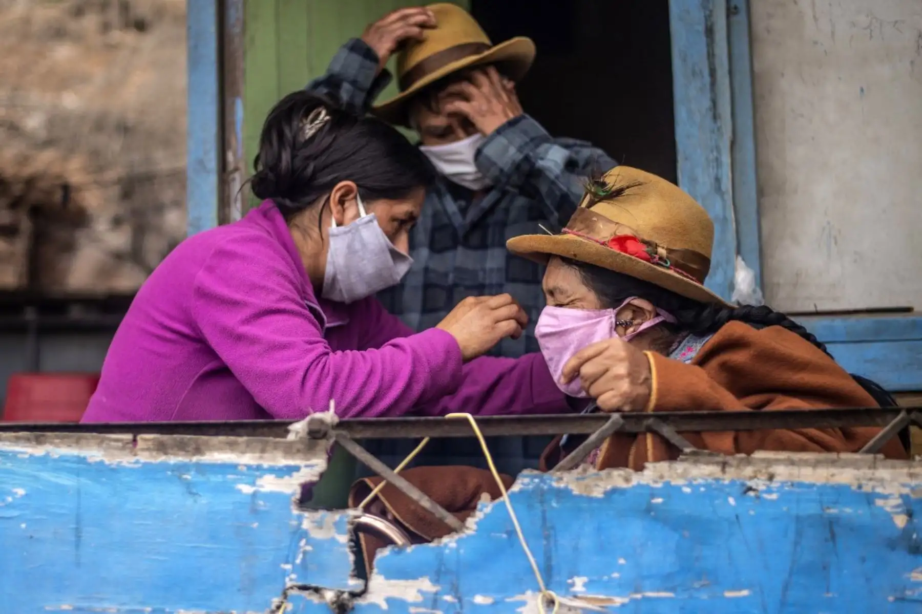 Una mujer arregla la máscara facial de su madre en su casa de la sección de Pamplona Alta. Foto: AFP