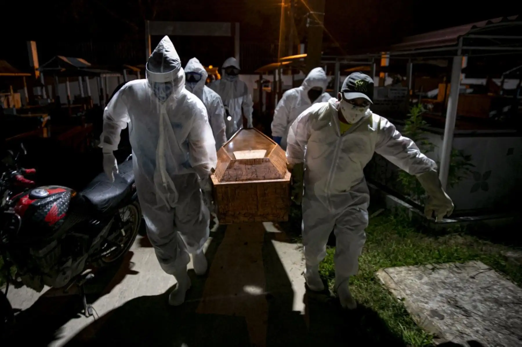 Los sepultureros con ropa protectora llevan el ataúd de una víctima del nuevo coronavirus COVID-19 para su entierro en el Cementerio Municipal de Recanto da Paz en la ciudad de Breves, Brasil. Foto: AFP