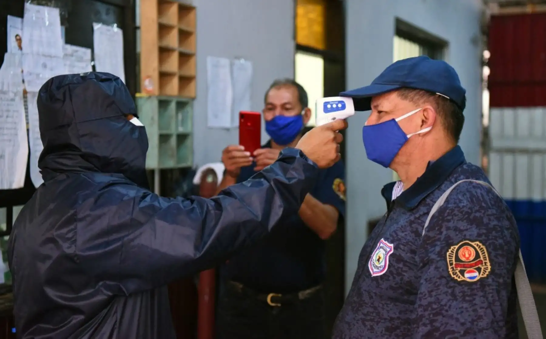 Un trabajador de salud toma la temperatura del personal en la prisión de Tacumbu en Asunción. Foto: AFP