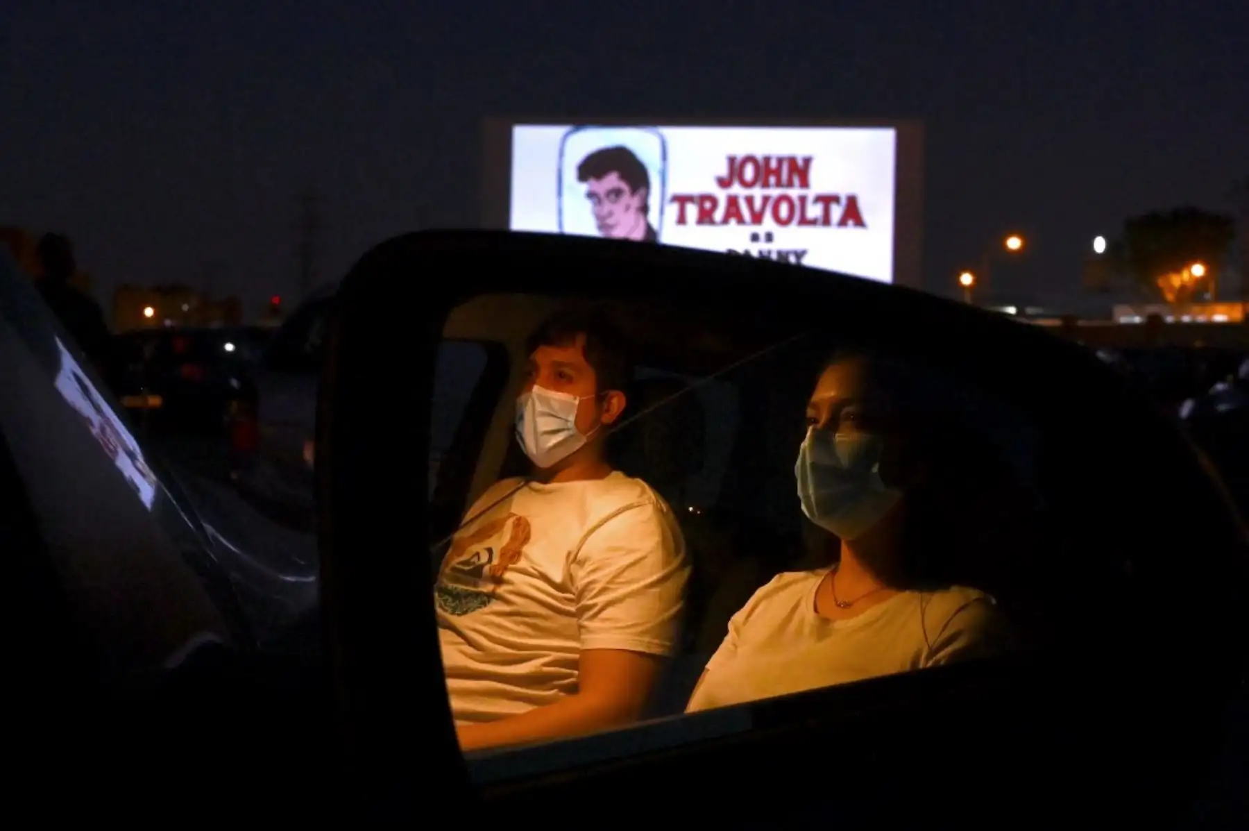 Los asistentes al cine en sus automóviles asisten a la proyección de la película de comedia romántica musical estadounidense "Grease" durante la reapertura del autocine Madrid Race Drive. Foto: AFP
