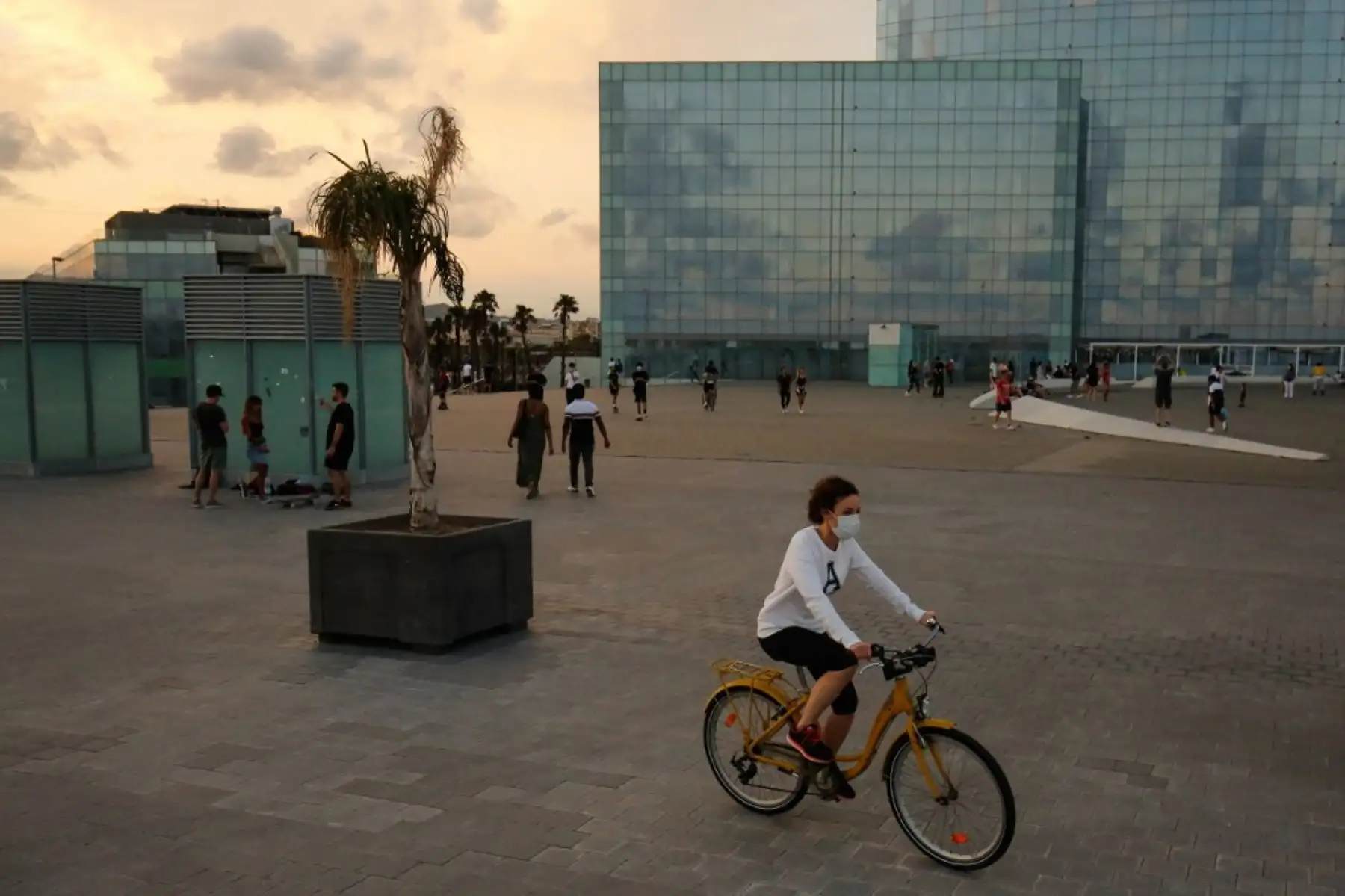 Una mujer monta una bicicleta en el paseo marítimo de la playa de la Barceloneta en Barcelona. Foto: AFP
