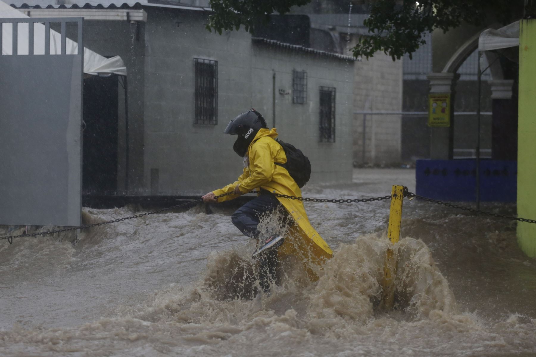 n persona intenta cruzar una calle inundada debido al paso de la tormenta tropical Amanda en San Salvador (El Salvador). Foto: EFE