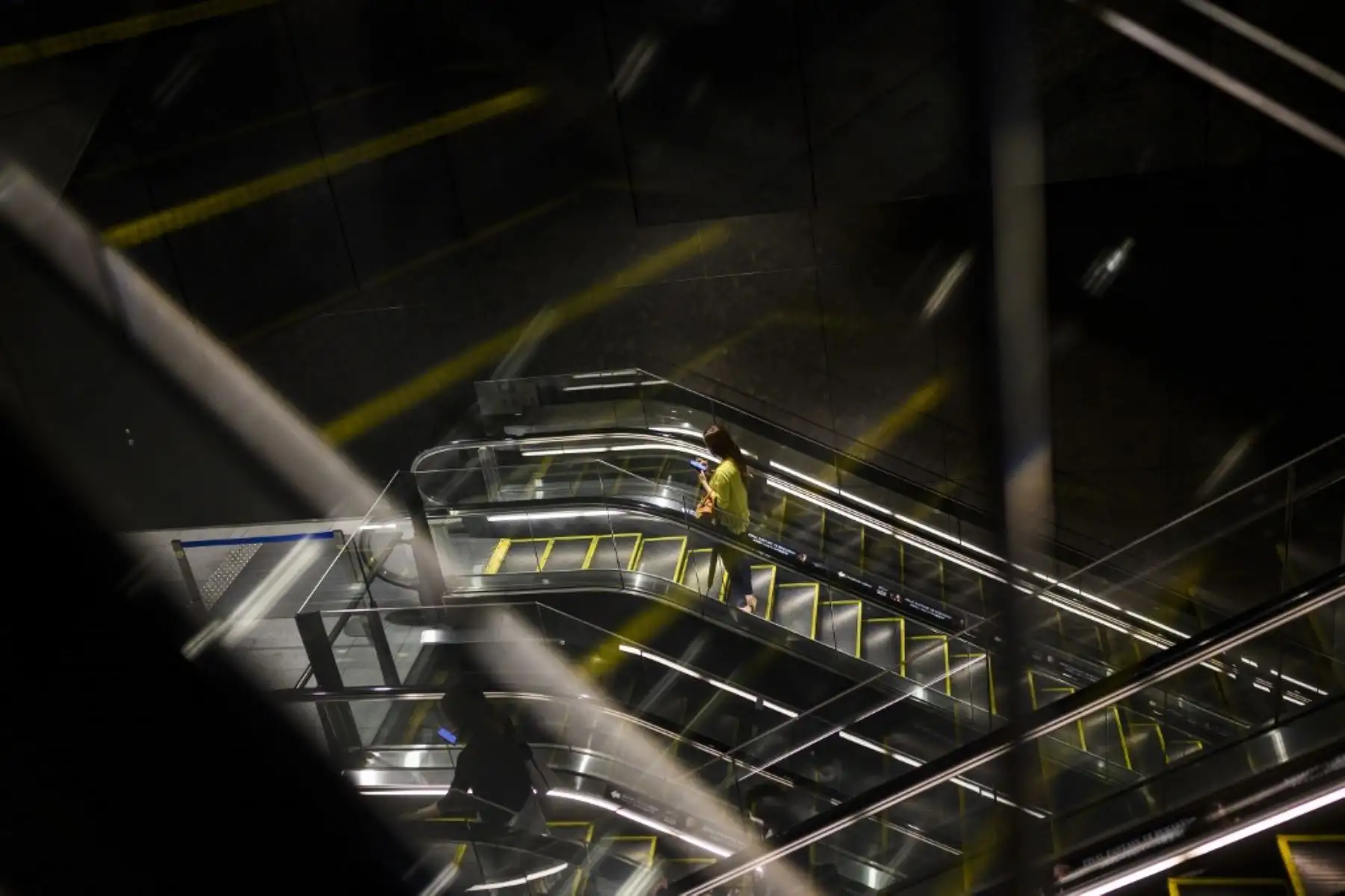 Una mujer que llevaba una máscara facial se sube a una escalera mecánica en el centro comercial Tokyo. Foto: AFP