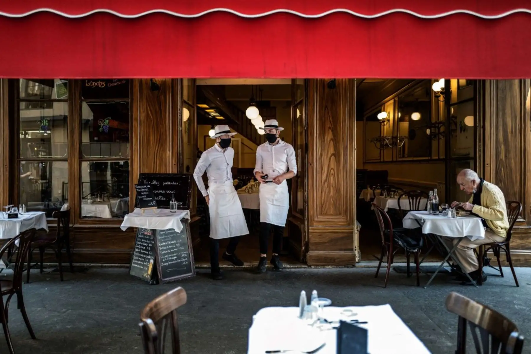 Los camareros se encuentran a la entrada de un restaurante local típico conocido como "Bouchon Lyonnais", el 2 de junio de 2020 en Lyon. Foto: AFP