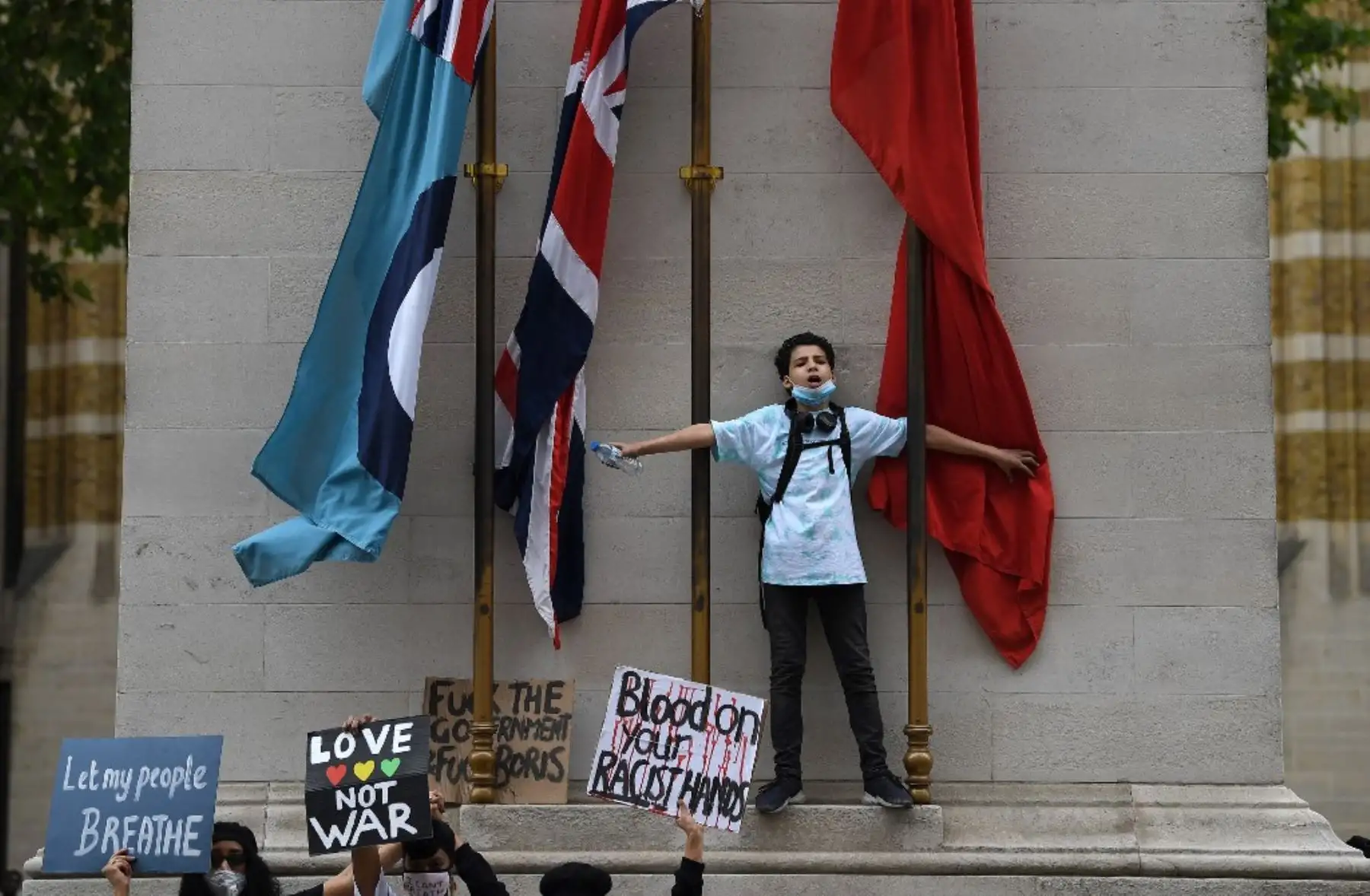 Manifestantes sostienen pancartas como demuestran en el memorial de guerra del Cenotafio en Whitehall durante una manifestación antirracista en Londres. Después de que George Floyd, un hombre negro desarmado murió después de que un oficial de policía se arrodilló en su cuello durante un arresto en Minneapolis
Foto: AFP