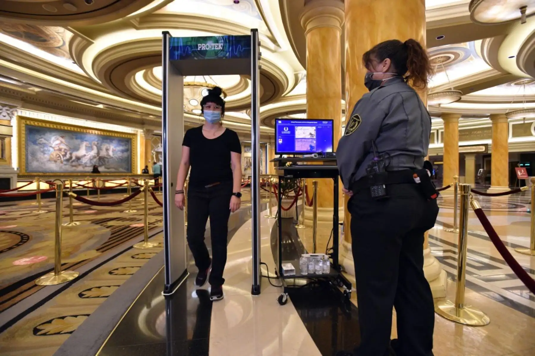 Una mujer pasa a través de un termómetro infrarrojo en el Caesars Palace en Las Vegas Strip, ya que la propiedad abre por primera vez desde que cerró el 17 de marzo debido a la pandemia de coronavirus (COVID-19). Foto: AFP