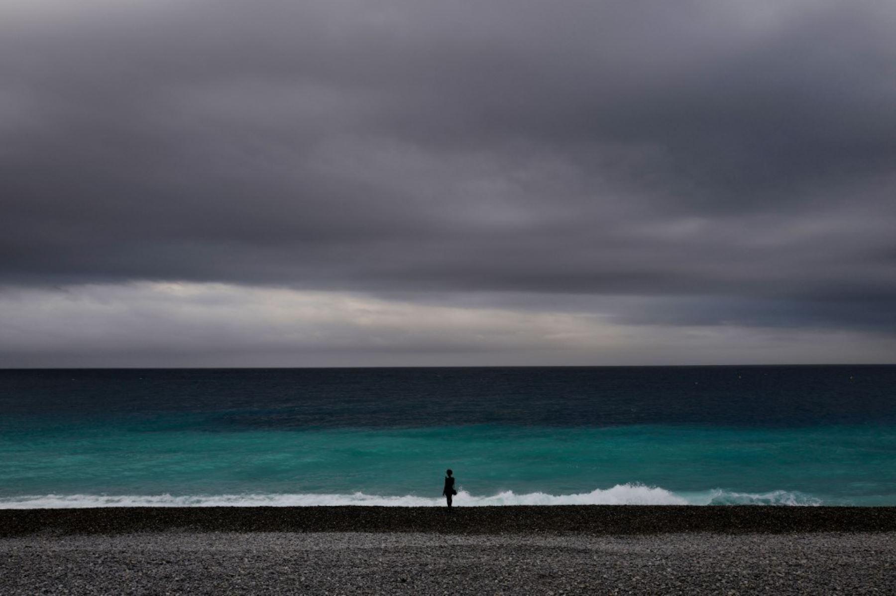 Una mujer mira el mar Mediterráneo desde la playa de la ciudad francesa de Niza, en el sur de Francia. Foto: AFP