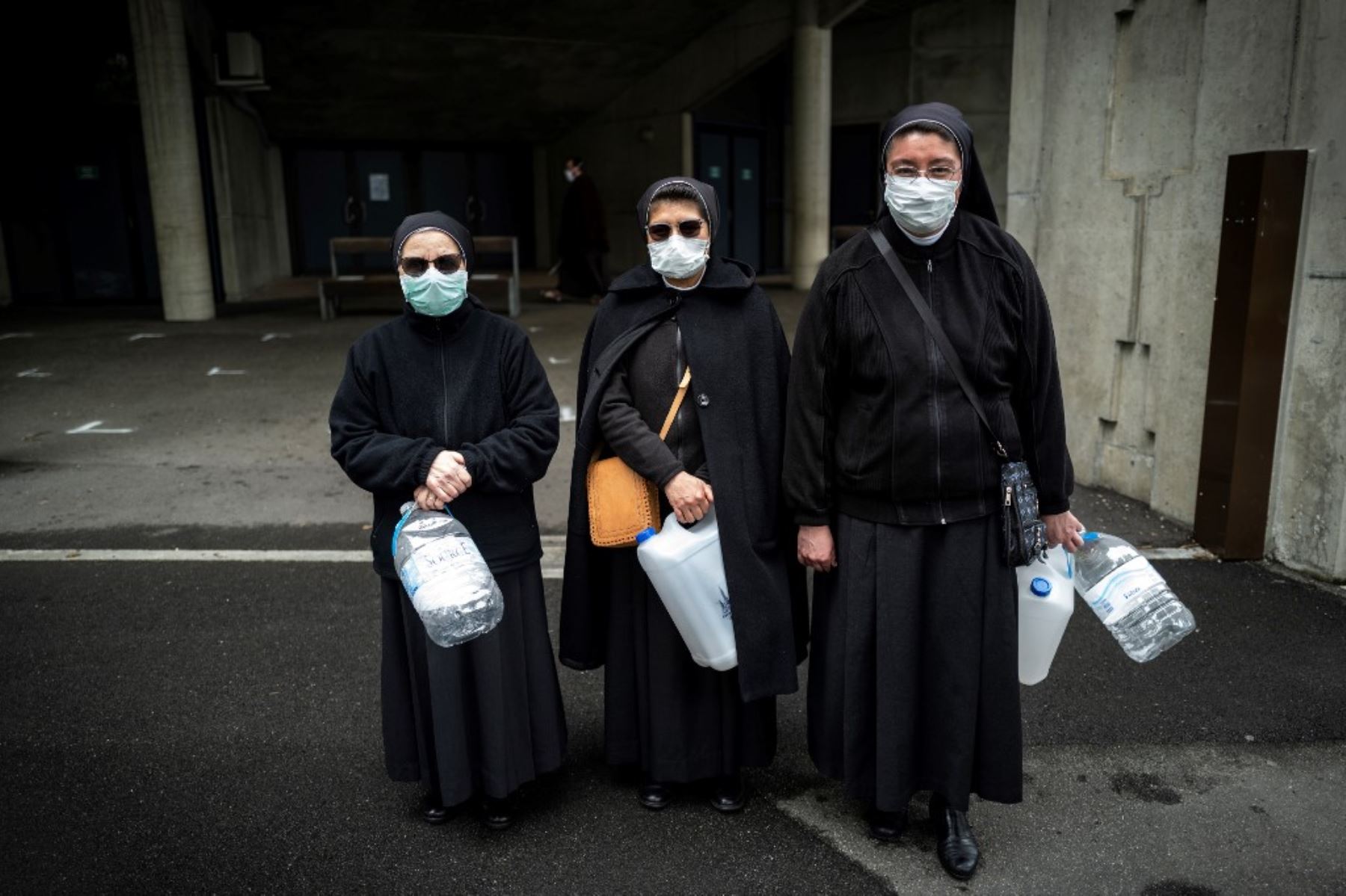 Los peregrinos con máscaras faciales esperan para recoger agua en el Santuario de Nuestra Señora de Lourdes en Lourdes, suroeste de Francia. Foto: AFP