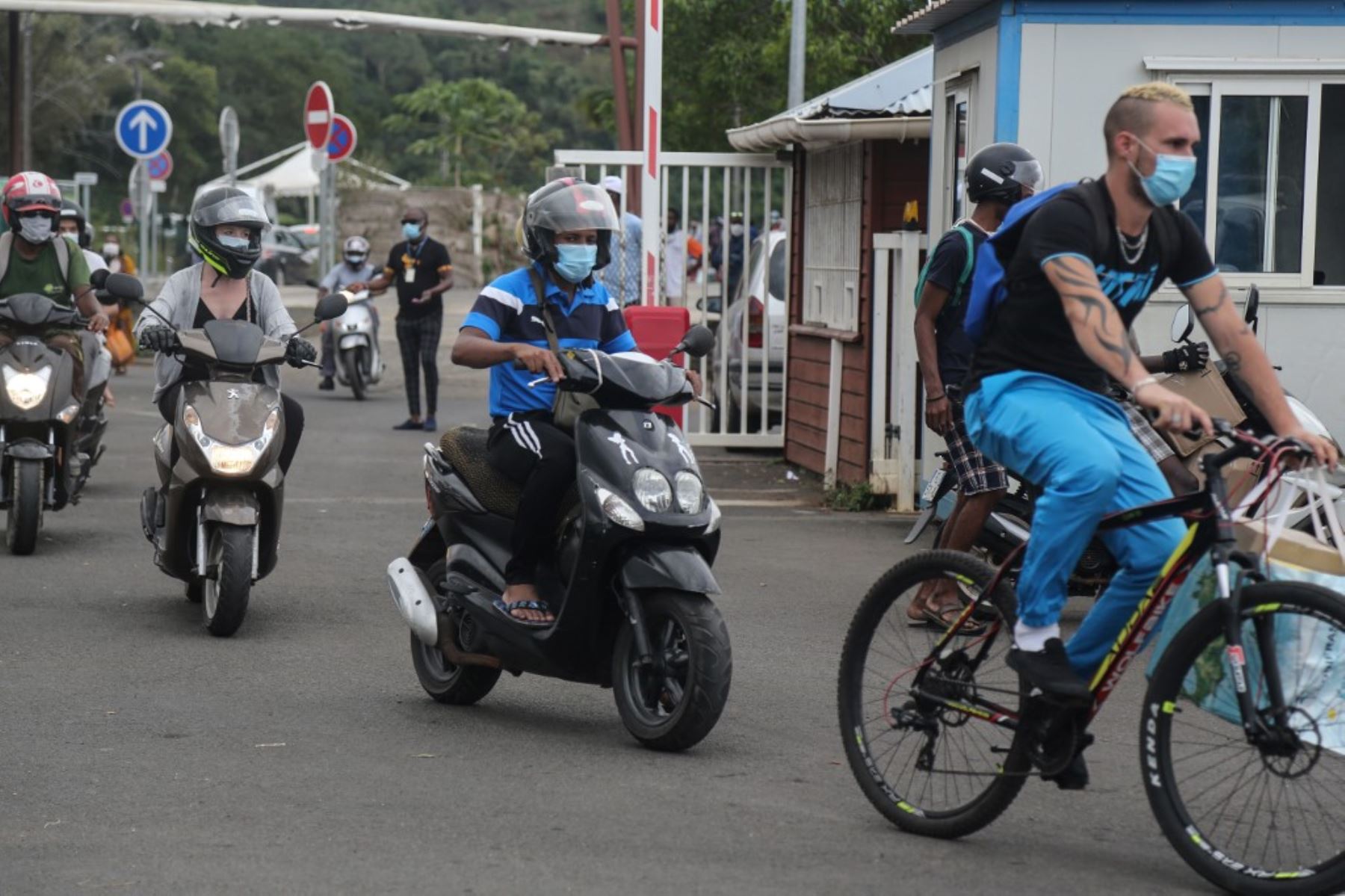 Los pasajeros de bicicletas y scooters con máscaras protectoras se dirigen a bordo del ferry en Mamoudzou, en la isla francesa de Mayotte, en el Océano Índico. Foto: AFP