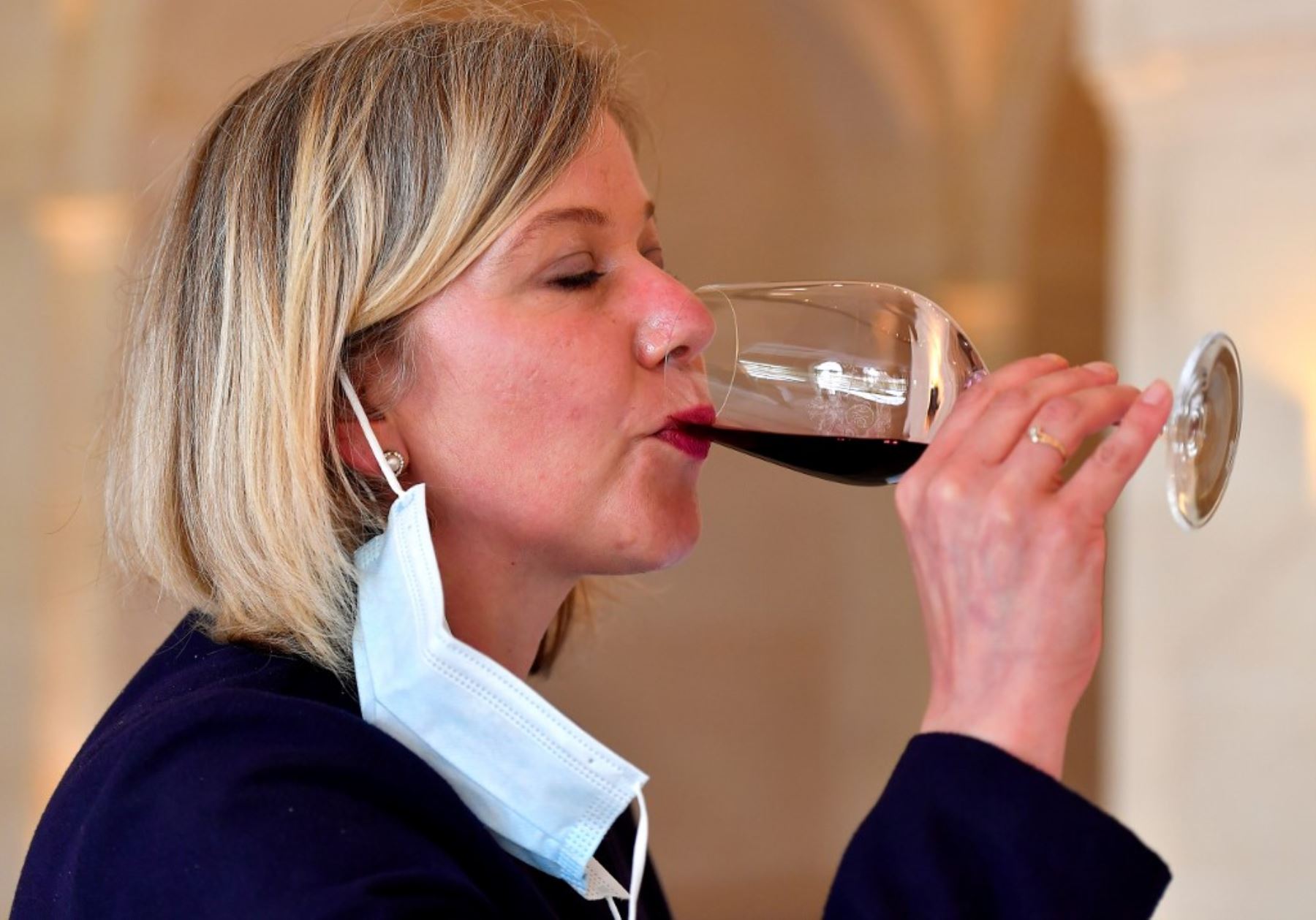 Una mujer quita su mascarilla y prueba vino en la finca vinícola Chateau Montrose en Saint-Estephe, cerca de Burdeos. Foto: AFP