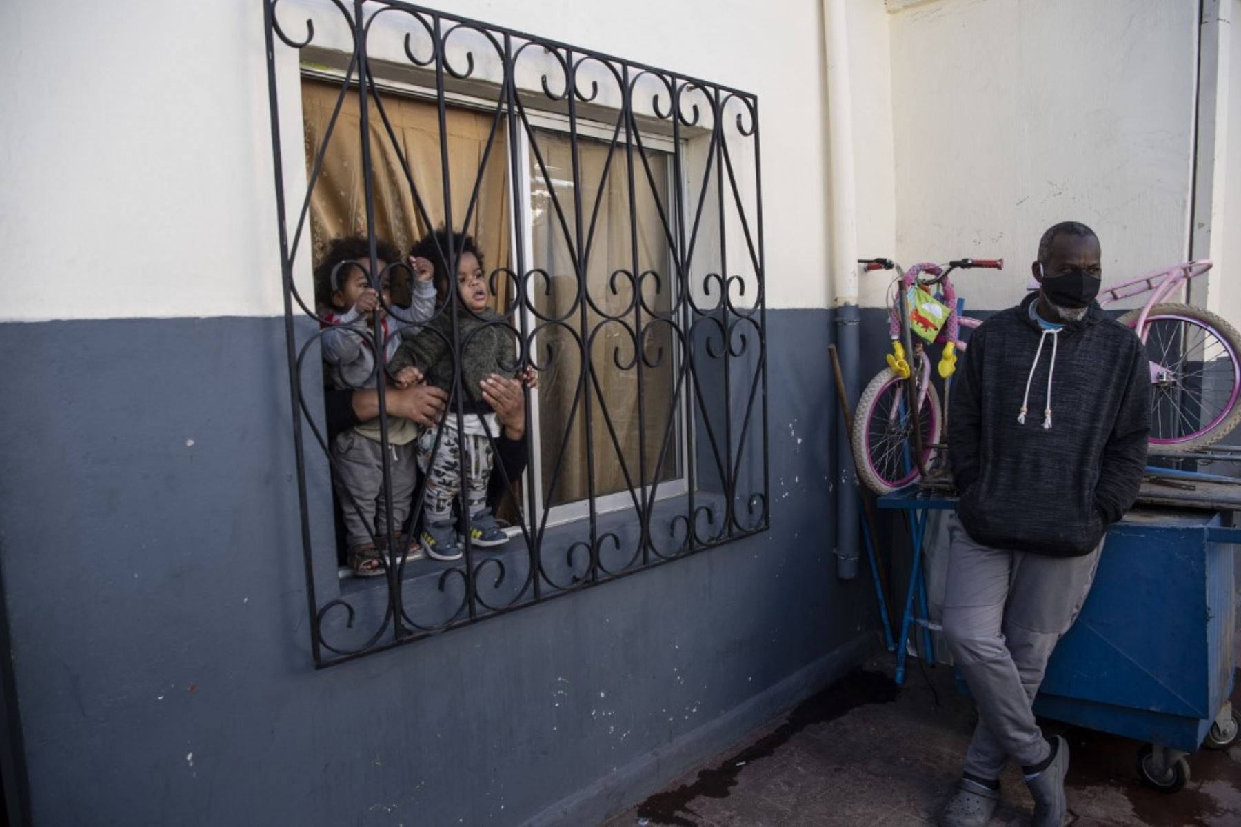 Una familia espera recibir una caja con alimentos entregados por trabajadores municipales a familias económicamente afectadas durante la cuarentena obligatoria ordenada por el gobierno chileno debido a la pandemia de coronavirus COVID-19, en Santiago. Foto: AFP