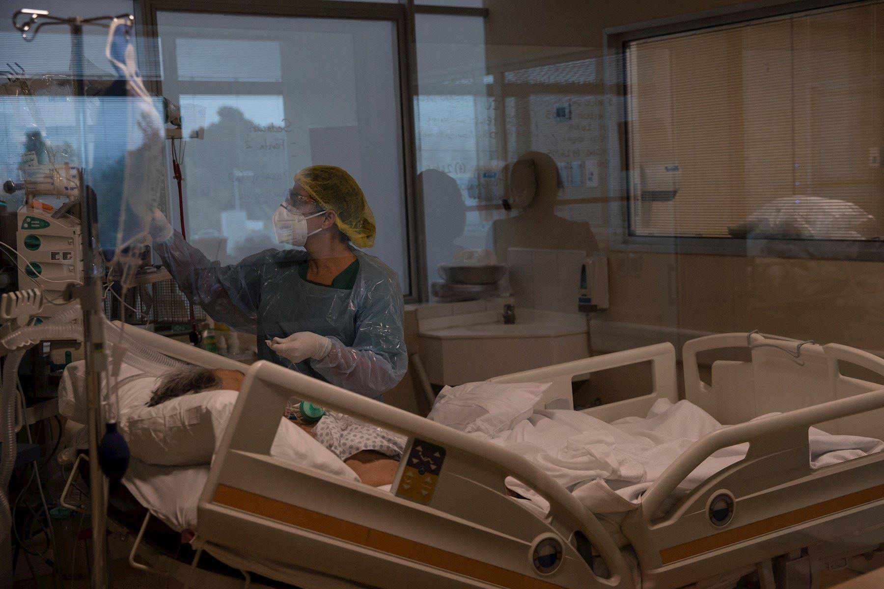 Una doctora del Hospital Militar revisa los signos vitales de un paciente con la COVID-19 que permanece entubado, este martes, en Santiago. Foto: EFE