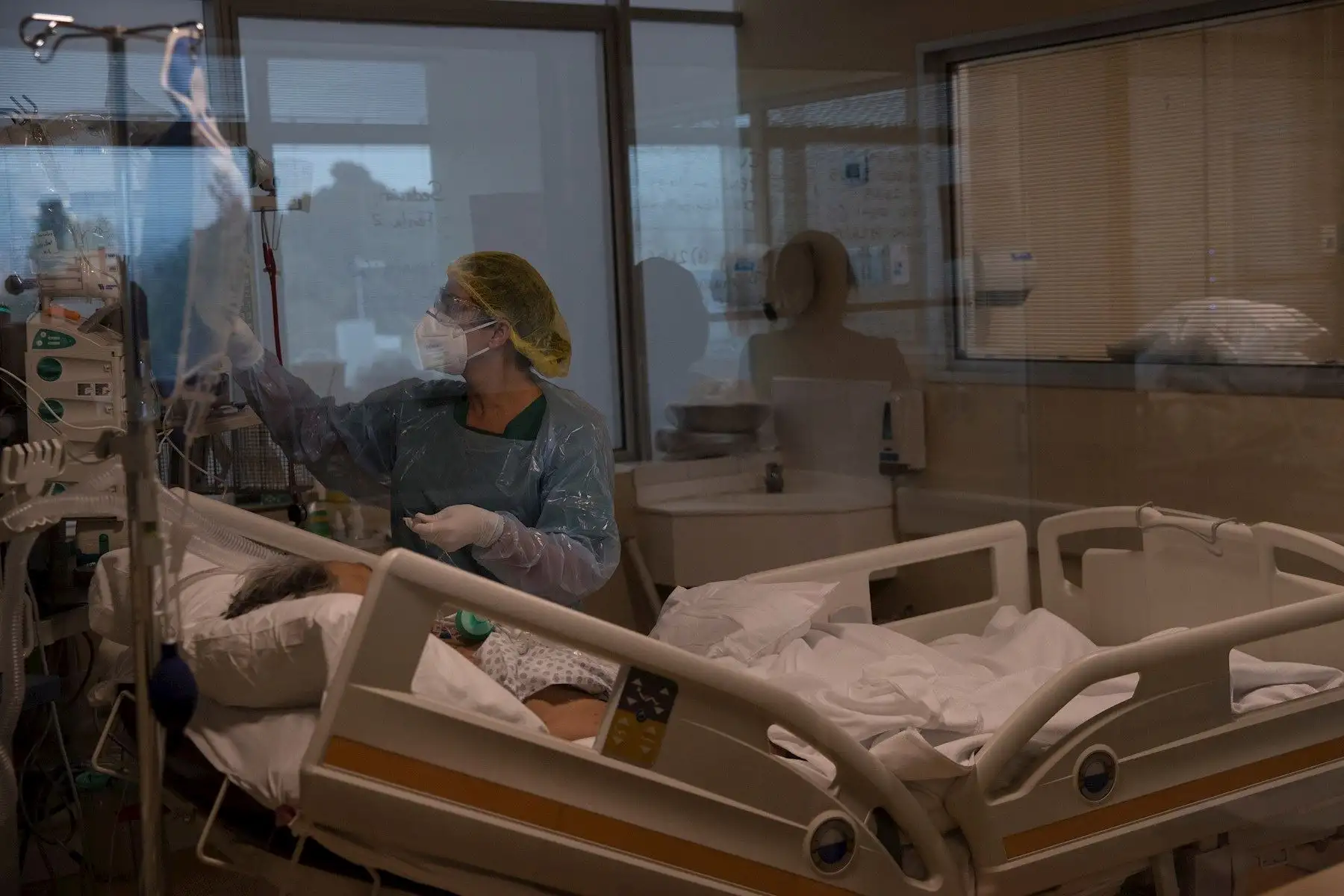 Una doctora del Hospital Militar revisa los signos vitales de un paciente con la COVID-19 que permanece entubado, este martes, en Santiago. Foto: EFE